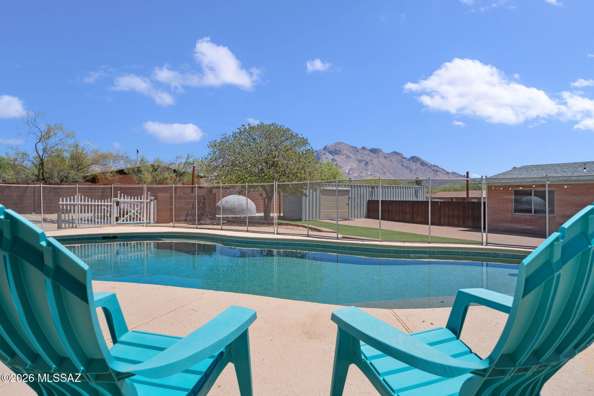 Nestled in the heart of Oro Valley, this beautifully maintained 3-bedroom, 2-bath home offers comfort, versatility, and stunning Catalina Mountain views. The open-concept kitchen flows seamlessly into the main living area, perfect for entertaining and everyday living. One guest bedroom features built-in office cabinetry, creating an ideal workspace or study area. Step outside to your private backyard retreat with a sparkling pool, playground, greenhouse, pizza oven and storage container. Enjoy breathtaking desert sunsets and the best of Arizona indoor-outdoor living. Listing agent is related to seller.