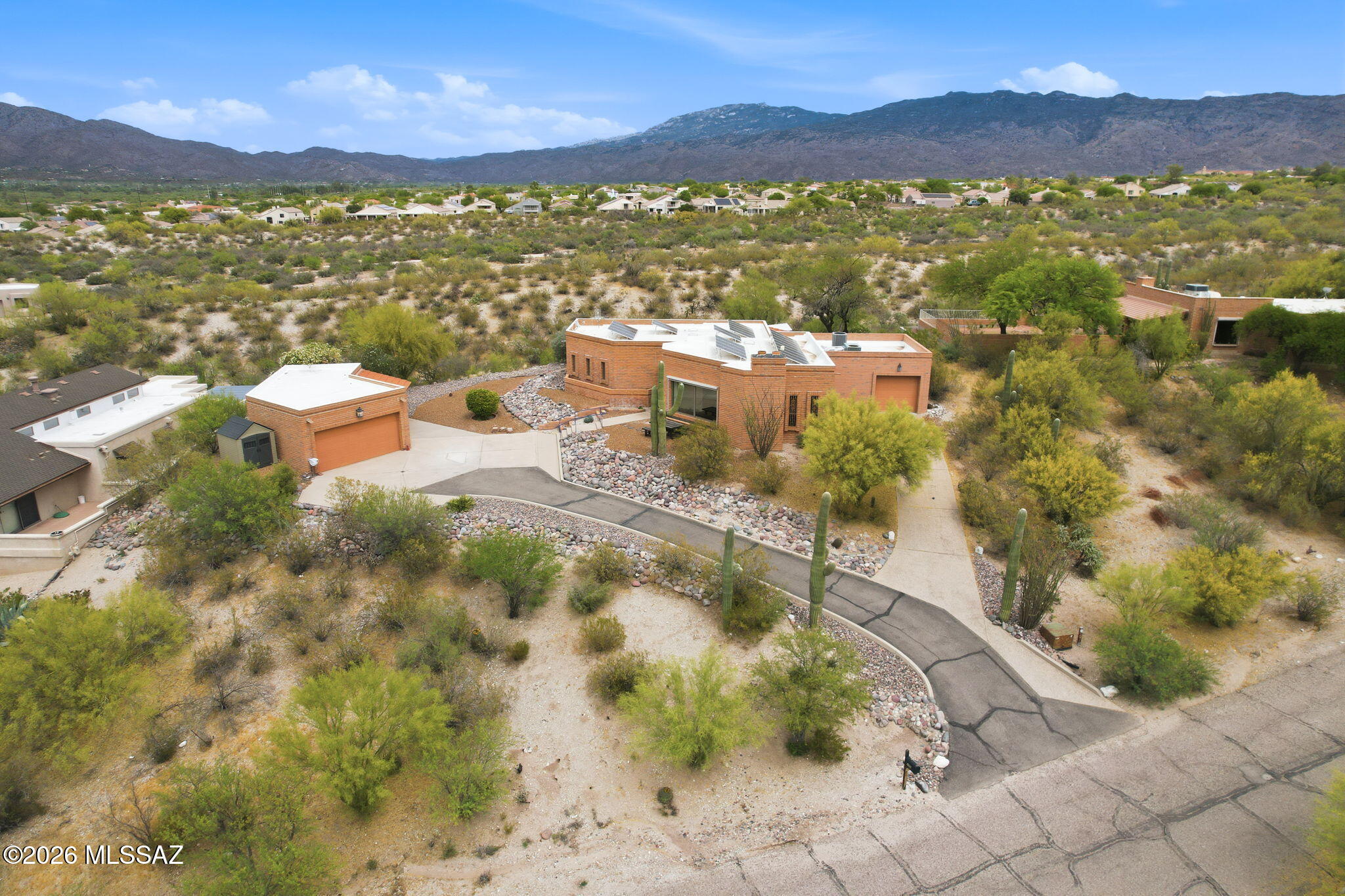 A standout feature of this 3 Bedroom property is the separate Studio with a full bathroom--ideal for an artist's retreat, yoga space, home office, or guest quarters.  Nestled in a desirable eastside location, this exceptional property is an off the beaten path hidden gem yet close to all city amenities.  Enjoy breathtaking panoramic views of the desert landscape, Catalina and Rincon Mountains, and stunning sunrises right from your own backyard. Relax on the tranquil patio as you take in the natural beauty that surrounds you. The beautifully maintained grounds feature mature desert landscaping, iconic saguaros, and a charming lemon tree, creating a serene and picturesque setting. Enhancing both comfort and efficiency, the home is equipped with solar power and an EV charger. Inside, the home showcases high vaulted tongue-and-groove ceilings that add warmth and character, along with a custom wet bar complete with a wine cooler--perfect for entertaining. The upgraded kitchen boasts modern counters and appliances designed for both style and functionality. Additionally, the third garage bay includes built-in cabinetry and offers flexible use as a home gym, workshop, or craft space. Unwind in the outdoor sauna after a long day and embrace the peaceful lifestyle this unique property provides. This one-of-a-kind home truly captures the essence of desert living with modern conveniences--don't miss the opportunity to make it yours.