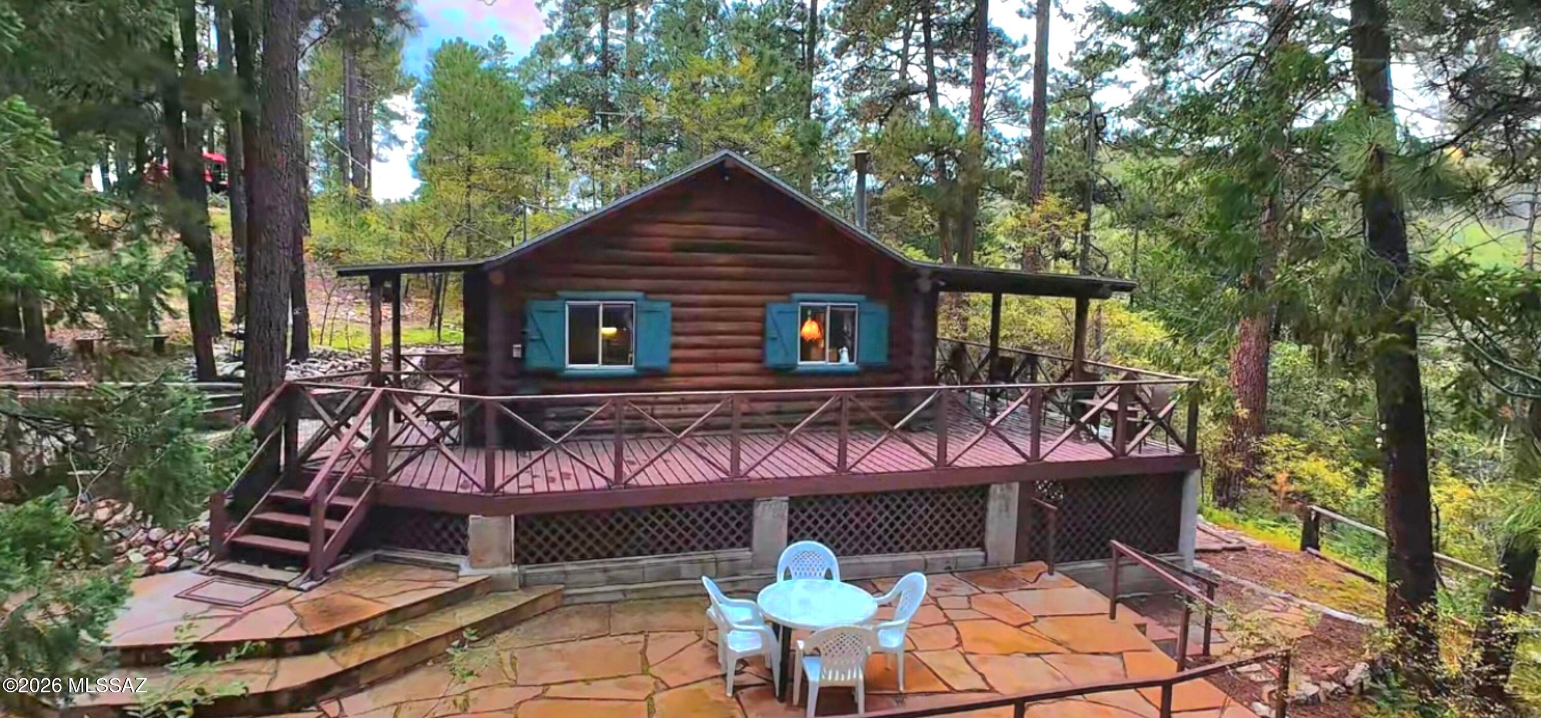 Escape the Tucson heat and discover your own mountain retreat in Summerhaven! Nestled among tall pines, this charming 480 sq. ft. cabin sits on over 1/3 acre and offers cool mountain air, cozy evenings, and true getaway living. Featuring 1 bedroom, 3/4 bath, a loft with queen mattress for the kido's, and a cozy wood-burning stove for chilly nights. Enjoy the huge wrap-around deck or gather on the expansive flagstone patio for BBQs, outdoor dining and relaxing. A converted outhouse serves as a laundry/utility room with an additional bathroom for the ''boys''. The neighborhood offers paved roads for easy access to enjoy all four seasons and is perfect for scenic mountain walks. This is a rare opportunity to own your very own peaceful escape just outside of the Tucson heat!