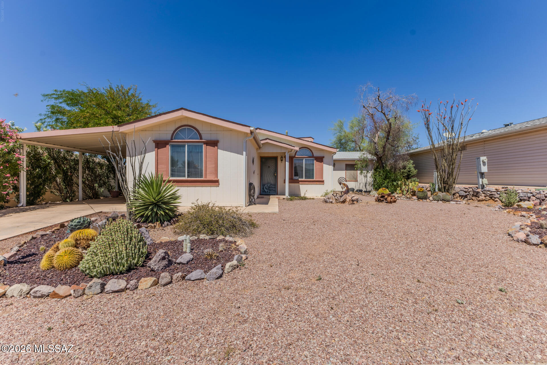 Priced to sell. Enjoy owning this lovely 2-bedroom home featuring carport parking and low-care desert landscape! Check out the inside to find an inviting living room that flows seamlessly into the dining area. Vaulted ceilings add to the airy feel, complemented by a blend of tile & carpet flooring, a neutral palette, and lots of natural light. In the kitchen, you will have matching appliances, a mosaic tile backsplash, plenty of cabinet space, and solid surface counters. The primary bedroom offers a sitting room, a walk-in closet, and a private bathroom for added comfort. Fantastic Arizona room adds extra space, perfect for entertaining guests, arts and crafts or relaxing year-round.