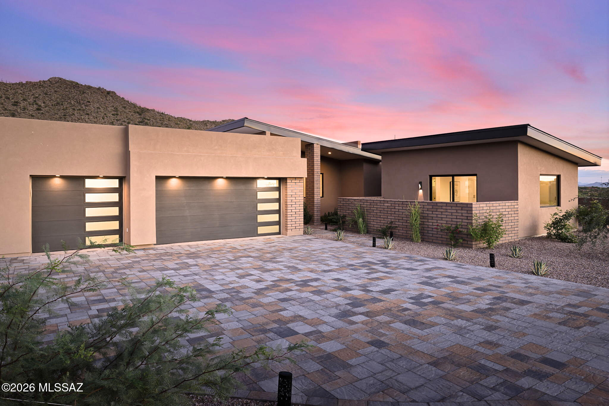 Welcome to Tranquility at The Overlook, a new statement of luxury & intentional design. This newly completed home fuses contemporary architecture w/ the serene spirit of nature. Located in the exclusive double-gated enclave of The Overlook at Gallery Golf Club at Dove Mountain, this residence is surrounded by sweeping mountain & golf course views. Circles & waves are repeated throughout in lighting & imported Spanish tile, reflecting a design philosophy centered on peace & calm. This thoughtfully designed floorplan features three bedrooms each w/ its own ensuite bath, a dedicated office, & a private guest casita. Every element of this home was crafted to evoke calm, balance, & connection to the natural landscape. The moment you arrive, the 12-foot pivot entry door and soaring ceilings create an unforgettable first impression. Natural light floods through walls of glass, highlighting an interior palette of warm white oak, soft neutral tones, and fine natural materials. Every design element was selected with purpose. Circular and wave patterns appear throughout, from high-end contemporary lighting to dimensional Spanish tile, representing balance, peace, and the rhythmic beauty of nature.

The open-concept great room serves as the heart of the home, anchored by a stunning fireplace wall wrapped in imported tile and a floating quartz hearth that glows softly with under-lighting. Above, the custom white-oak ceiling design adds texture and warmth, creating a sense of organic sophistication. Seamlessly connected to the great room, the chef's kitchen is a work of art in itself, featuring flat-panel cabinetry, champagne-gold hardware, a circular marble backsplash, and an expansive quartzite waterfall island with seating for five. A walk-in pantry with butcher-block counters and built-in outlets provides discreet space for prep and storage, allowing the kitchen to maintain its clean, contemporary aesthetic.

The home's layout flows effortlessly from shared living spaces to private retreats. The primary suite offers a spa-like ambiance with fluted tile, polished porcelain, and a freestanding soaking tub perfect for quiet relaxation. Each guest suite features an ensuite bath designed with the elegance of a boutique hotel, complete with backlit mirrors, custom tilework, and refined fixtures. The dedicated office captures tranquil views of the mountains and golf course, balancing productivity with inspiration.

Even the functional spaces were designed with intention. The laundry room pairs playful sage cabinetry with a circle-pattern backsplash that was hand-set tile by tile, blending artistry with everyday utility. The detached casita provides guests with privacy and comfort, including a wet bar, microwave, and beverage fridge for a true retreat experience.

Throughout Tranquility at The Overlook, the design language remains consistent, organic shapes, light natural materials, and a calm tonal palette work together to create an environment that feels peaceful, restorative, and timeless. This is more than a home; it is an experience of architectural artistry and modern refinement, designed to bring balance to the way you live every day.