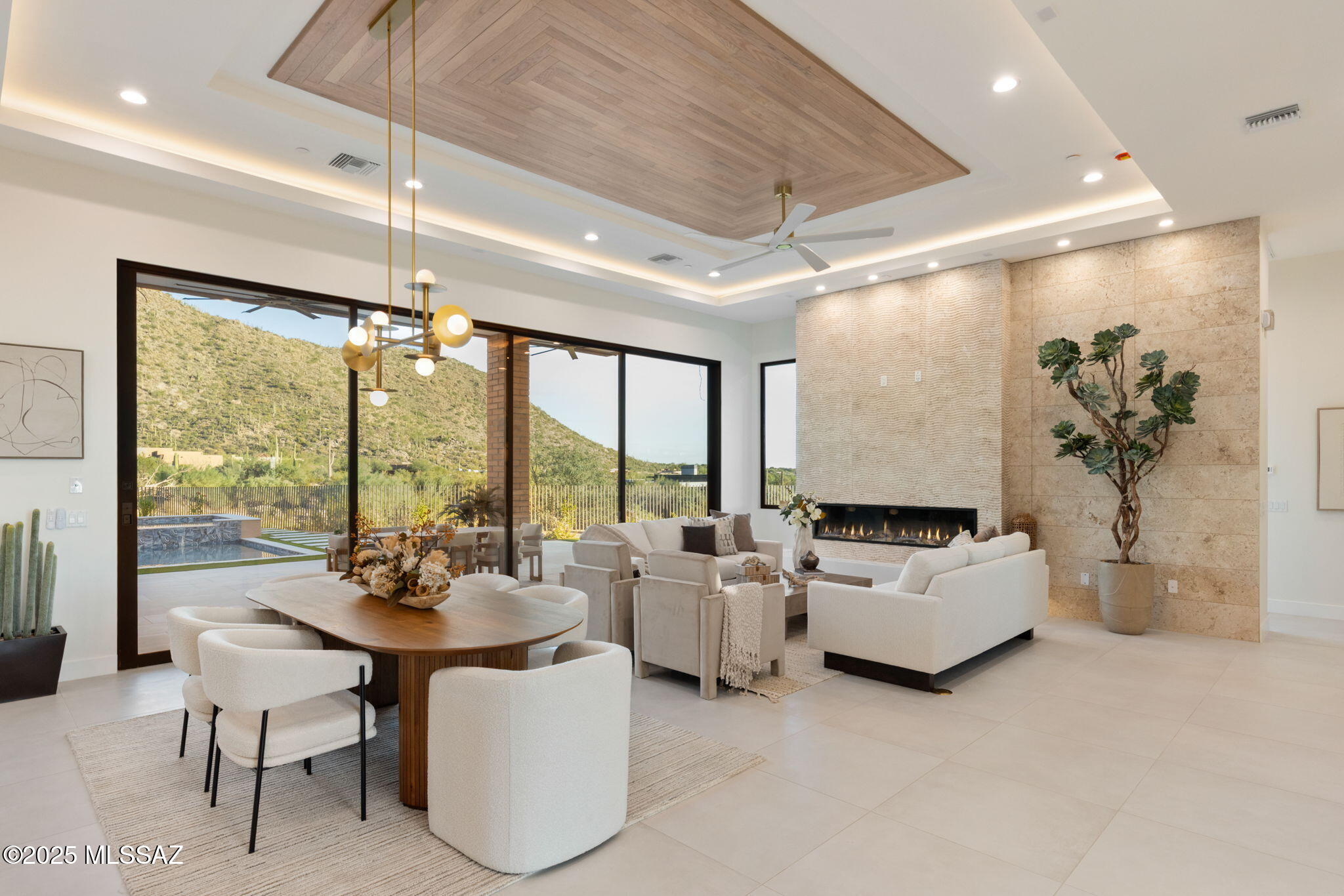 Welcome to Tranquility at The Overlook, a new statement of luxury & intentional design. This newly completed home fuses contemporary architecture w/ the serene spirit of nature. Located in the exclusive double-gated enclave of The Overlook at Gallery Golf Club at Dove Mountain, this residence is surrounded by sweeping mountain & golf course views. Circles & waves are repeated throughout in lighting & imported Spanish tile, reflecting a design philosophy centered on peace & calm. This thoughtfully designed floorplan features three bedrooms each w/ its own ensuite bath, a dedicated office, & a private guest casita. Every element of this home was crafted to evoke calm, balance, & connection to the natural landscape. The moment you arrive, the 12-foot pivot entry door and soaring ceilings create an unforgettable first impression. Natural light floods through walls of glass, highlighting an interior palette of warm white oak, soft neutral tones, and fine natural materials. Every design element was selected with purpose. Circular and wave patterns appear throughout, from high-end contemporary lighting to dimensional Spanish tile, representing balance, peace, and the rhythmic beauty of nature.

The open-concept great room serves as the heart of the home, anchored by a stunning fireplace wall wrapped in imported tile and a floating quartz hearth that glows softly with under-lighting. Above, the custom white-oak ceiling design adds texture and warmth, creating a sense of organic sophistication. Seamlessly connected to the great room, the chef's kitchen is a work of art in itself, featuring flat-panel cabinetry, champagne-gold hardware, a circular marble backsplash, and an expansive quartzite waterfall island with seating for five. A walk-in pantry with butcher-block counters and built-in outlets provides discreet space for prep and storage, allowing the kitchen to maintain its clean, contemporary aesthetic.

The home's layout flows effortlessly from shared living spaces to private retreats. The primary suite offers a spa-like ambiance with fluted tile, polished porcelain, and a freestanding soaking tub perfect for quiet relaxation. Each guest suite features an ensuite bath designed with the elegance of a boutique hotel, complete with backlit mirrors, custom tilework, and refined fixtures. The dedicated office captures tranquil views of the mountains and golf course, balancing productivity with inspiration.

Even the functional spaces were designed with intention. The laundry room pairs playful sage cabinetry with a circle-pattern backsplash that was hand-set tile by tile, blending artistry with everyday utility. The detached casita provides guests with privacy and comfort, including a wet bar, microwave, and beverage fridge for a true retreat experience.

Throughout Tranquility at The Overlook, the design language remains consistent, organic shapes, light natural materials, and a calm tonal palette work together to create an environment that feels peaceful, restorative, and timeless. This is more than a home; it is an experience of architectural artistry and modern refinement, designed to bring balance to the way you live every day.
