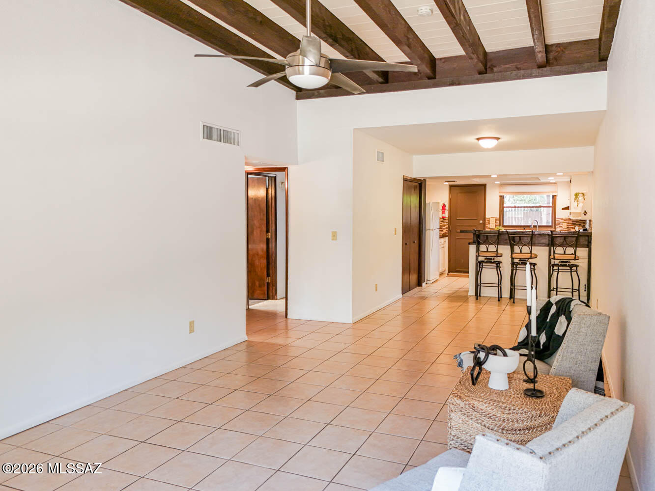 Make yourself right at home in this charming condo in Casas Presidio! Step into a cozy living room featuring a rustic wood-plank ceiling and exposed beams that add the perfect touch of character. The kitchen is ready for your culinary adventures with ample counter space, crisp white cabinetry, and a breakfast bar for casual dining. The main bedroom offers direct access to the backyard along with a private bathroom, creating your own little retreat. Both bedrooms feature new carpet, and the bathrooms have been tastefully updated not too long ago. This unit is just a few steps from the community pool, offering both privacy and convenience. Located just a 10-minute drive to the UofA and Banner Medical Center.