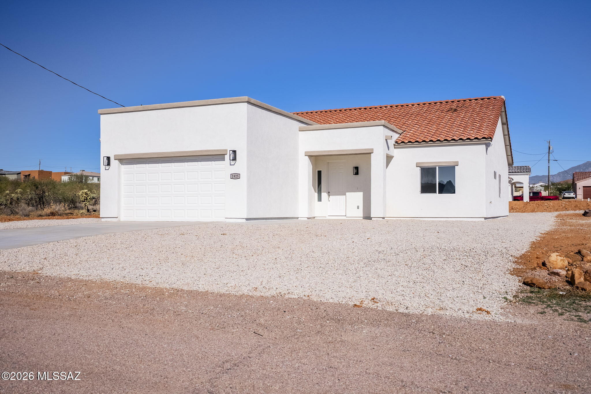 Enjoy beautiful mountain views & serene desert landscapes from this 3-bedroom, 2-bath new-construction home. Situated on a corner lot on a paved road with quick access to I-19, this property offers both tranquility and convenience—just minutes from shopping, dining, and only 45 minutes to Tucson. Step inside to a bright, open floor plan filled with natural light. The kitchen connects to the living and dining area, creating an ideal space for entertaining or relaxing with family. Upgraded finishes include tile flooring, high ceilings, tile roof, granite countertops, and upgraded lighting /plumbing fixtures. The MB offers a large walk-in closet and a dual-sink vanity. This home offers comfort, style, and a great location.