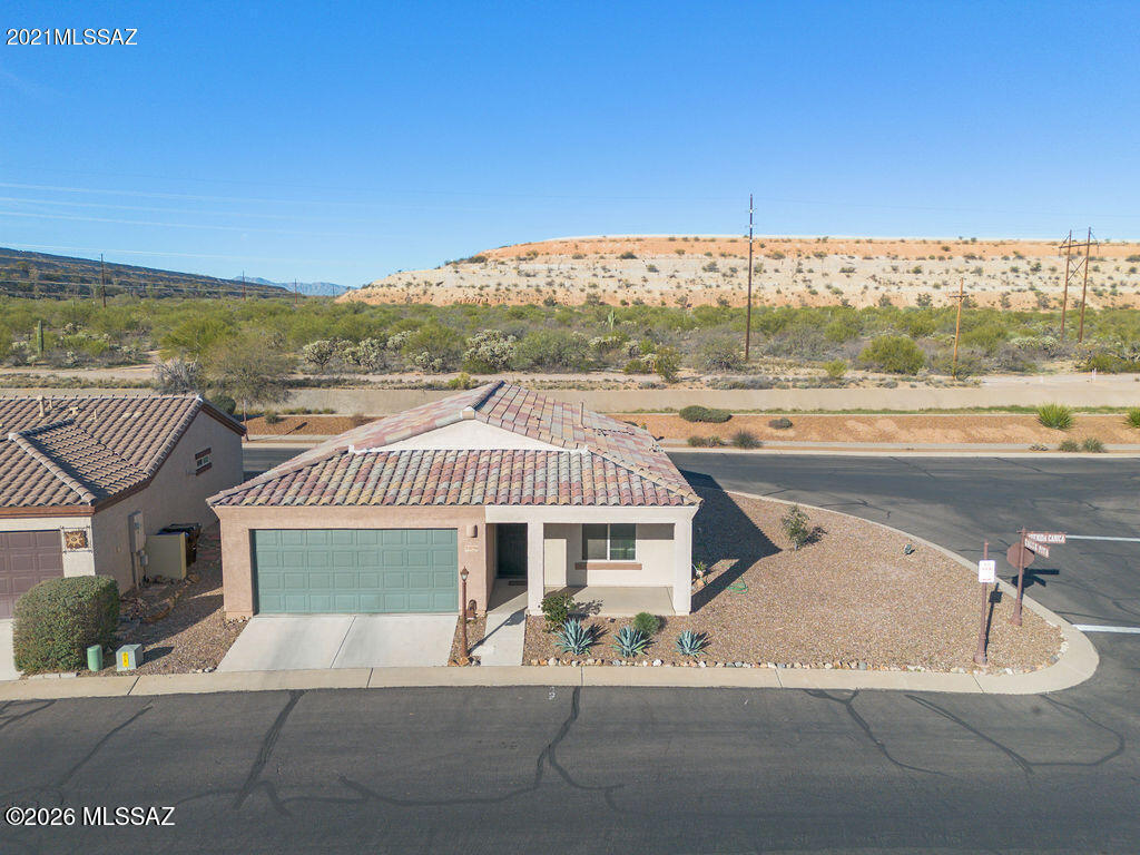 Discover this charming corner-lot home in the desirable Rancho Resort 55+ community. Offering 950 square feet of comfortable living space, this well-maintained 2-bedroom, 1-bath residence features a rare two-car garage—ideal for both seasonal and full-time living in Sahuarita. The prime corner-lot placement provides exceptional privacy, with only one adjacent neighbor, streets on three sides, and a peaceful common area directly behind the home.