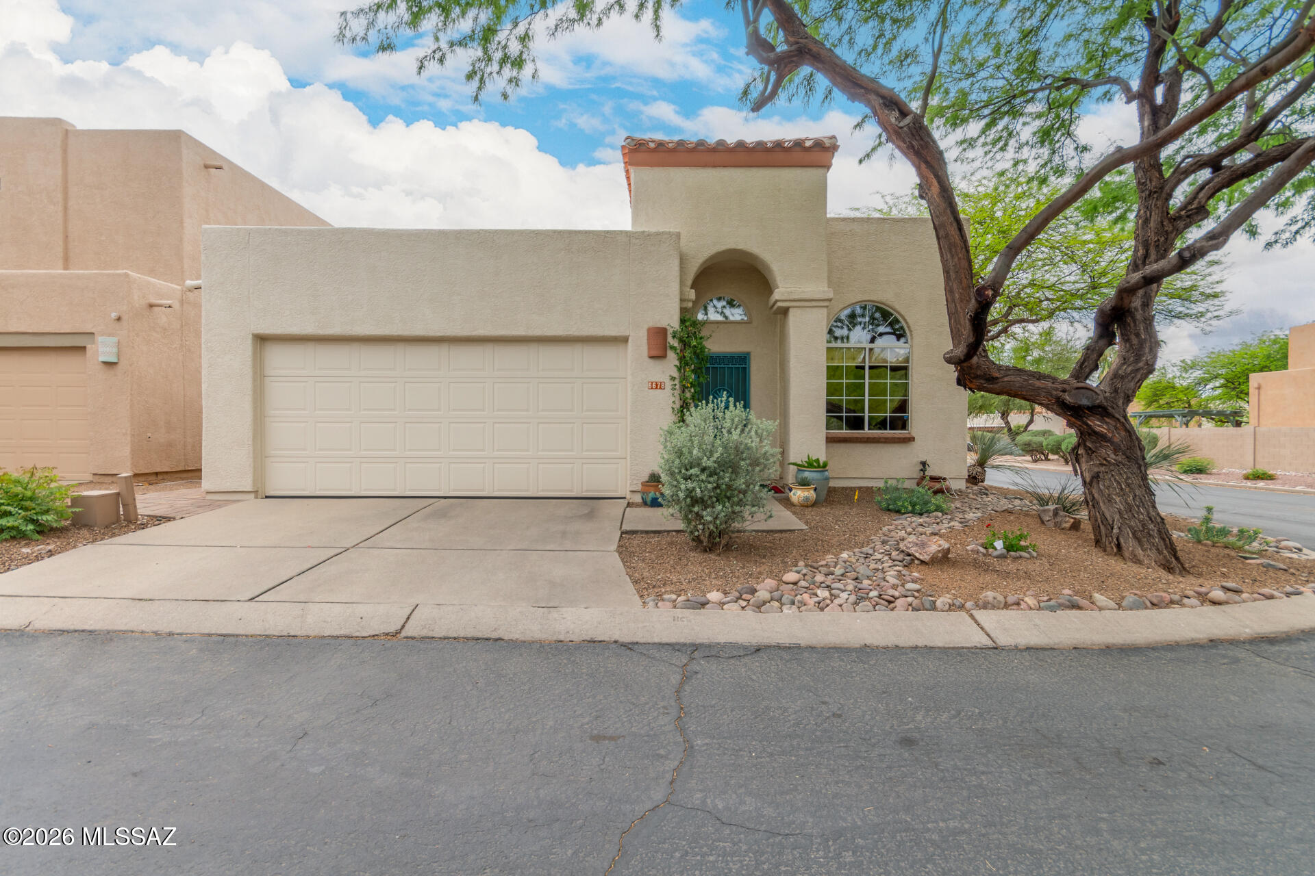 Rare opportunity in the beautiful Mesquite Creek II neighborhood with sparkling community pool! Perfectly situated on a corner lot, with newer HVAC (Dec. 2025) and OWNED solar.   This thoughtfully updated home offers nearly 1,700 sq. ft. of inviting living space with 3 bedrooms, 2 bathrooms, beautiful porcelain tile flooring throughout and soaring ceilings--creating a bright and open feel. Enter into a welcoming formal living room/dining area that flows seamlessly into a stunning kitchen featuring crisp cabinetry, rich butcher block countertops, quartz breakfast bar, a custom backsplash, and sleek stainless steel appliances including a high-end induction range. The adjacent family room includes an upgraded sliding glass door leading to the rear patio, perfect for indoor and outdoor living. The spacious primary bedroom features an en suite bathroom with granite countertop vanity, custom-tiled shower, a walk-in closet and a bonus bypass closet. Two private guest bedrooms and a full guest bathroom provide comfort and flexibility. Additional highlights include woven wood window shades, a large laundry room and a 2-car garage with built-in cabinets. Step outside to enjoy a serene, covered patio, extended paver seating area, and lush yet low-maintenance landscaping. Ideally located near shopping, dining, schools, the Tucson Loop/river park, Sabino Canyon Recreation Area and more.   This home is truly a must see!