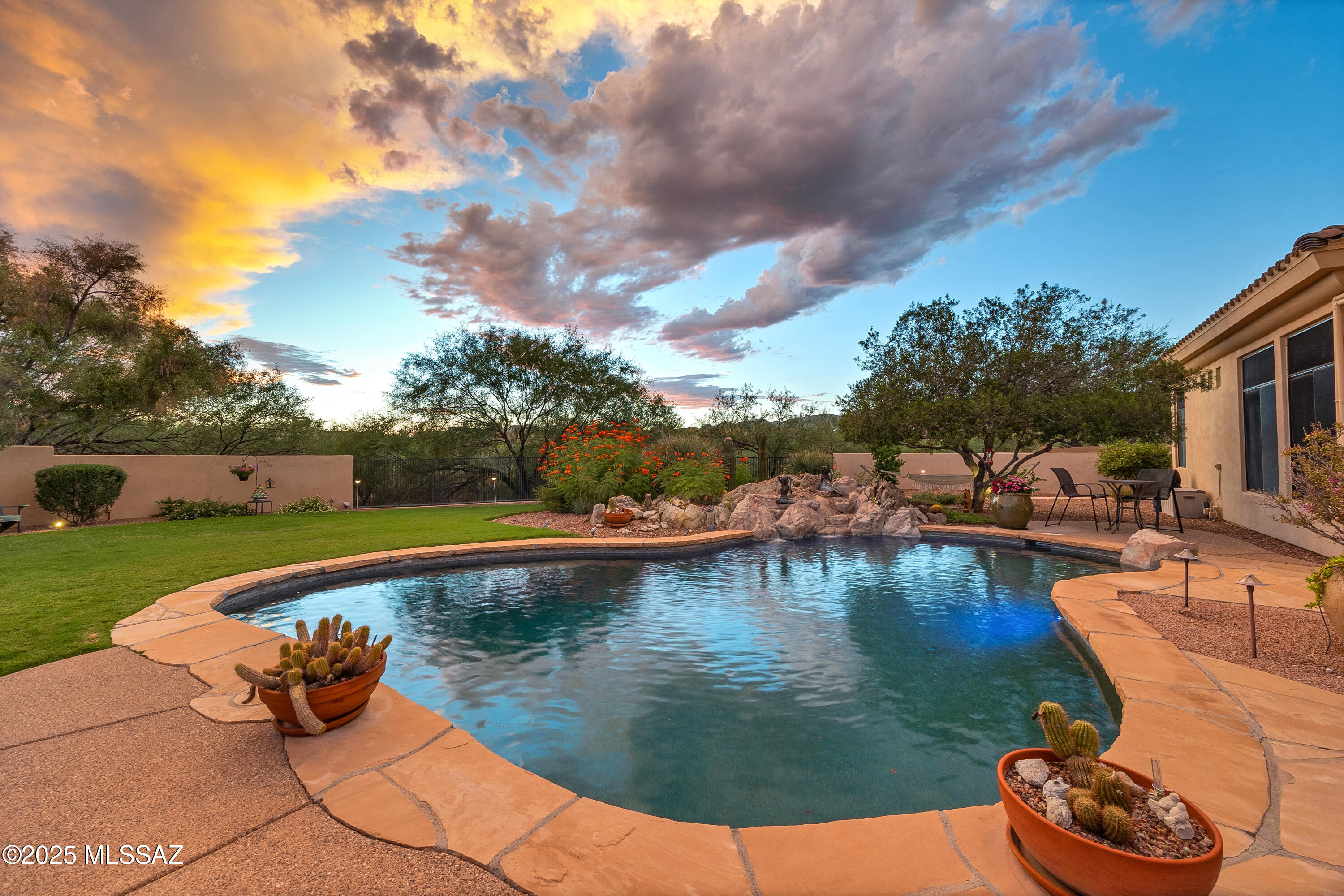 Welcome to a truly one of a kind gated residence, where timeless elegance meets modern comfort.
Enter through a charming front courtyard into a bright and expansive interior, where a wall of windows fills the home with natural light and connects indoor living with the stunning desert surroundings. Designed for effortless entertaining and comfortable everyday living, this home offers multiple refined living spaces suited for any occasion. With 4 spacious bedrooms and 3 bathrooms, the layout is both functional and luxurious. The fourth bedroom offers flexibility and can easily serve as a  media room, work out room  or creative studio.
At the heart of the home is a chef's dream kitchen, featuring premium finishes, generous storage, and ample counter space — the ideal setting for creating and sharing unforgettable meals and sharing wonderful memories.

The primary suite is a serene retreat, offering privacy and comfort with gorgeous views of the back yard. The recently renovated spa-style bathroom boasts a large walk-in shower, soaking tub, bidet toilet, heated towel rack, and a thoughtfully designed oversized walk-in closet.

Step outside to your resort-style backyard oasis, set on a spacious lot that backs to open space for ultimate privacy. Enjoy breathtaking views of the Catalina and Tortolita Mountains, all from the deep lagoon-style pool with a soothing waterfall and color-changing LED lighting that adds a magical touch at night.

The deep covered patio is equipped with electronic sunscreens and a misting system, creating the perfect space for year-round relaxation or entertaining. There's ample room to add a custom outdoor kitchen, garden beds, or more lounge areas. Fruit trees enhance the landscape, offering both charm and serenity.

Lovingly maintained, this home reflects pride of ownership in every detail and is ready to welcome new owners to create lasting memories.
Located in a quiet, exclusive enclave of homes, this property sits on one of the area's most desirable streets  known for its tranquility, sense of community, and pride of ownership.  

You will Enjoy direct access to scenic nature trails, ideal for biking, walking, or simply appreciating the desert's natural beauty and wildlife and sunsets. 

Conveniently close to top-rated schools, hiking trails, parks, golf, hospitals, fine dining, and more, this exceptional home offers the perfect balance of privacy and accessibility  an ideal retreat without compromise.