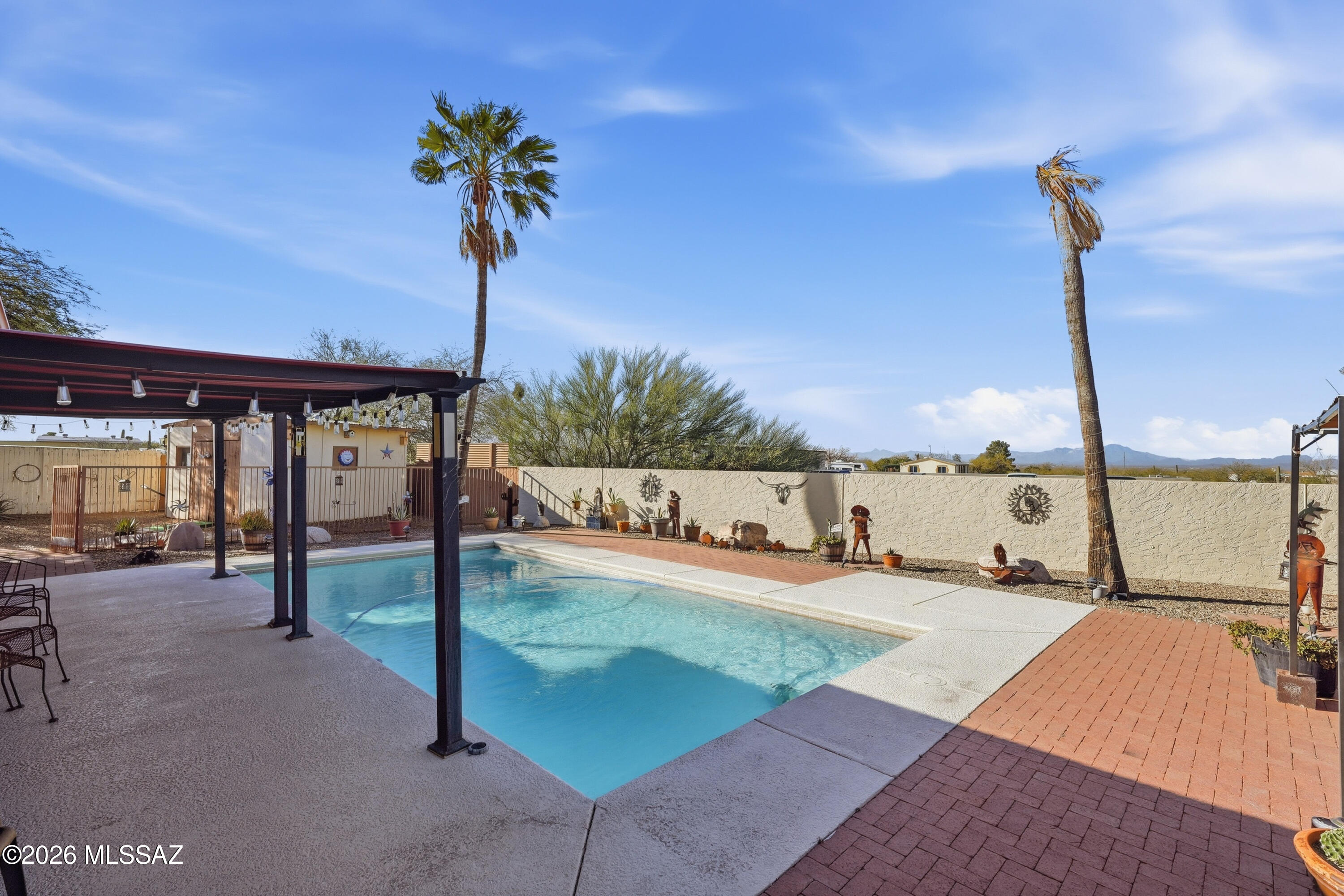 Desert gem on a desirable corner lot with stunning panoramic mountain views. Situated on a spacious 1-acre lot, this property offers privacy, open desert surroundings, and room to enjoy Arizona living. The home features large front and rear Arizona rooms with elegant wrought iron screens spanning the length of the home, creating great indoor-outdoor living space. The backyard includes a refreshing underground pool and brick patio, perfect for relaxing or entertaining. Conveniently located with access to shopping, dining, and everyday amenities, and just minutes from the hiking and biking trails of Tucson Mountain Park and the scenic desert beauty of Saguaro National Park.