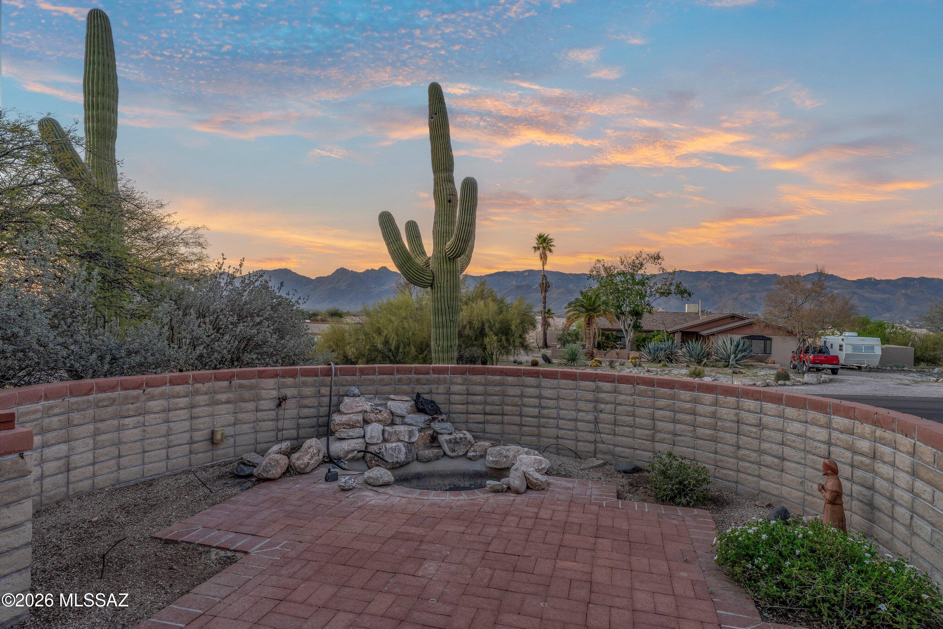 FRESH PRICE to go with the fresh paint! . A blank canvas situated on an exceptional .87-acre lot creates a truly iconic Sonoran Desert setting.  Elegant double front doors usher you into this charming territorial-style home with four bedrooms, 2.5 baths, a sparkling pool, and breathtaking Catalina and Rincon Mountain views. Durable slump block construction offers timeless quality and lasting appeal. Inside, you'll find spacious living areas that flow seamlessly throughout. A thoughtfully designed split-bedroom floor plan provides privacy and flexibility, making this home ideal for everyday living and entertaining. Bonus, large laundry room, spacious pantry as well as a workshop space in the garage.