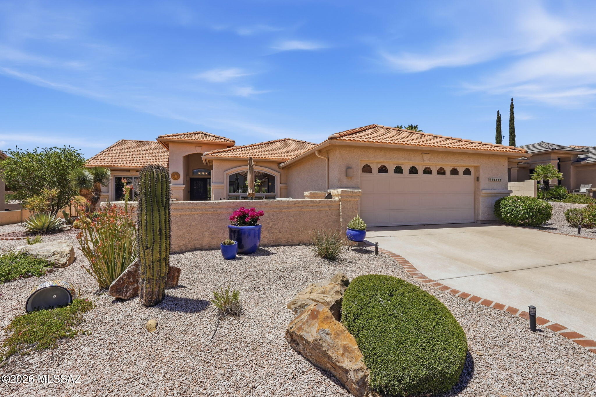 Welcome home to this meticulously remodeled Laredo model, where no detail has been overlooked! Situated on a quiet street in the premier Active Adult SaddleBrooke community, this 2BD/2BA (1,937 sqft) residence offers a ''better-than-new'' luxury feel, featuring high-end custom finishes and a tranquil desert backdrop that epitomizes Southern Arizona living. Step through the wrought-iron security door to discover a light-filled interior anchored by 20-inch diagonally laid tile floors and high, airy ceilings. The heart of the home is a stunning gourmet kitchen, reimagined with white cabinetry topped with elegant crown molding, high-end quartz counters, and a sleek farm-style sink. An expanded social island with pendant lighting and newer stainless-steel appliances, including a Bosch dishwashe and a 5-burner GE Profile range makes this kitchen a chef's delight. The primary suite is a true sanctuary, boasting a luxurious bath with a custom-tiled walk-in shower with dual heads, executive-height granite vanities, and a generous walk-in closet. A dedicated den with custom built-ins and a desk provides the perfect workspace, while the great room's lighted stacked-stone entertainment center adds a touch of modern sophistication. Enjoy some of the many upgrades, such as a Tesla EV charger, lighted mirrors and executive height counters in the primary bathroom, as well as a Nuvo water filtration and softener system. Outdoor living is exceptional here. The relaxing tiled patio features two ramadas and opens directly to a private backyard bordering a natural desert arroyo, perfect for quiet mornings or enjoying Tucson's famous sunsets in complete privacy. Complete with an extended 2-car garage and access to SaddleBrooke's world-class golf, pickleball, and fitness centers, this turn-key masterpiece is ready for its next chapter.