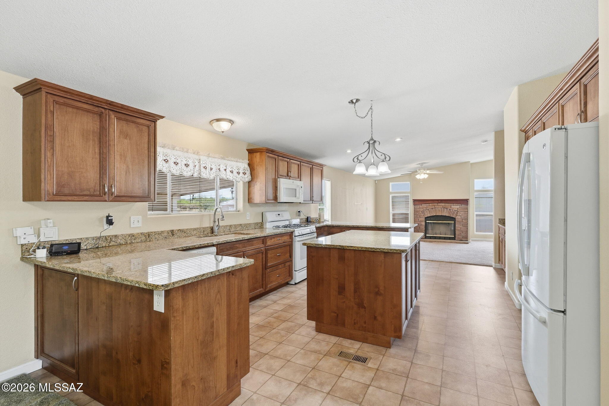 Spacious updated home in a desirable gated community with easy I-10 access. A community pool and park for residents adds appeal. The gorgeous remodeled kitchen with granite countertops, a large center island, extra cabinets and pull out drawers is truly a chef's kitchen. Features include a new roof, new garage door, storage shed, sun shades, drip irrigation, security doors, a split bedroom plan, double sink in both baths, a  stone fireplace and covered patio. The 2 car garage with an extra parking space also features an accessibility ramp leading to the french doors into the kitchen. The home also border the common area for extra privacy.  A lovely place to call home!
