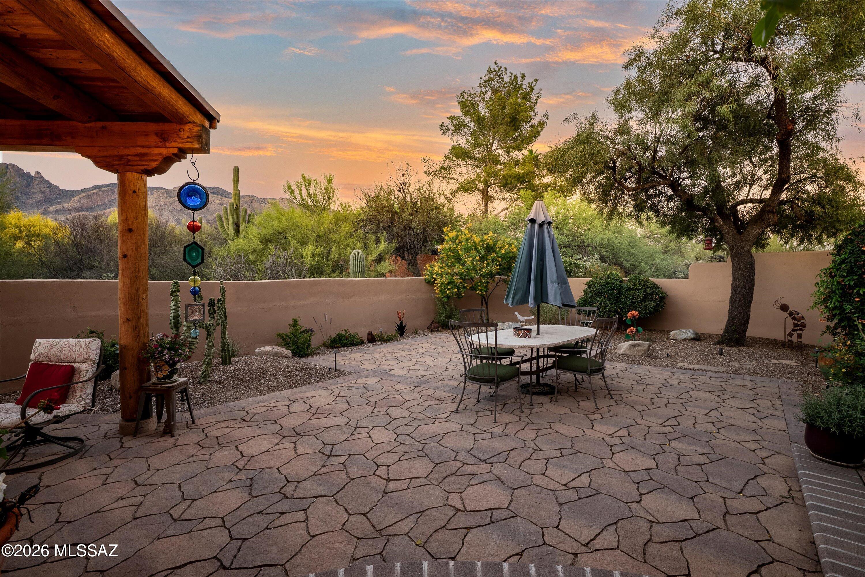 Stunning Southwestern 2.229 SF adobe home in the Foothills, set on a private desert 0.80-acre lot with sweeping mountain and sunset views.  This one-owner authentic residence showcases timeless Tucson character with exposed wood vigas and latillas, clerestory windows, smooth plaster walls, and softly rounded architectural lines throughout.  A welcoming entry with a custom wood door opens to an inviting interior where the open-concept living and dining spaces flow seamlessly together.  Soaring ceilings, rustic wood posts, built-in niches, and a charming beehive fireplace create warmth and architectural interest.  The dining room window is perfectly framed to capture views of the Catalina Mountains, and the living room French doors extend the living space outdoors onto a private patio. The thoughtfully designed kitchen blends function and style with warm wood cabinetry, striking granite countertops, and a full-height backsplash, stainless steel appliances, and a center island with casual seating--perfect for everyday living or entertaining.  Natural light and desert views from the kitchen window further elevate the space. 

This flexible family room with an open layout allows for comfortable seating and gatherings, is filled with natural light, and has French doors that open directly to the back patio.  Outdoor living features extensive pavers, adobe walls, and lush desert landscaping, offering multiple seating areas for dining, lounging, and entertaining.  A covered patio with rustic beams and ambient lighting creates a cozy gathering space, while the newer hot tub on the side patio provides a private setting to relax under the stars.
The primary suite offers a peaceful retreat with a beehive fireplace, cozy window seat, and serene desert views.  The spacious ensuite bath features dual vanities, artisan details, and a walk-in tiled shower.  Secondary bedrooms are well-sized and versatile, ideal for guests, office, or flex space, with generous storage and classic Southwestern finishes. 

Additional features include a long, curved driveway, energy-efficient systems with a heat pump and mini-split, Anderson windows with a transferable warranty, and Pella doors.  Extensive updates include backyard pavers and lighting (2020), kitchen appliances (2022), roof recoating (2023), water heater (2024), new kitchen cabinetry and garage door (2025), a 2-car garage, and a spacious laundry room.   Conveniently located near Catalina Foothills High School, shopping, dining, and an easy drive to the U of A campus, this home offers a rare blend of privacy, character, and effortless desert living, a true Arizona lifestyle.