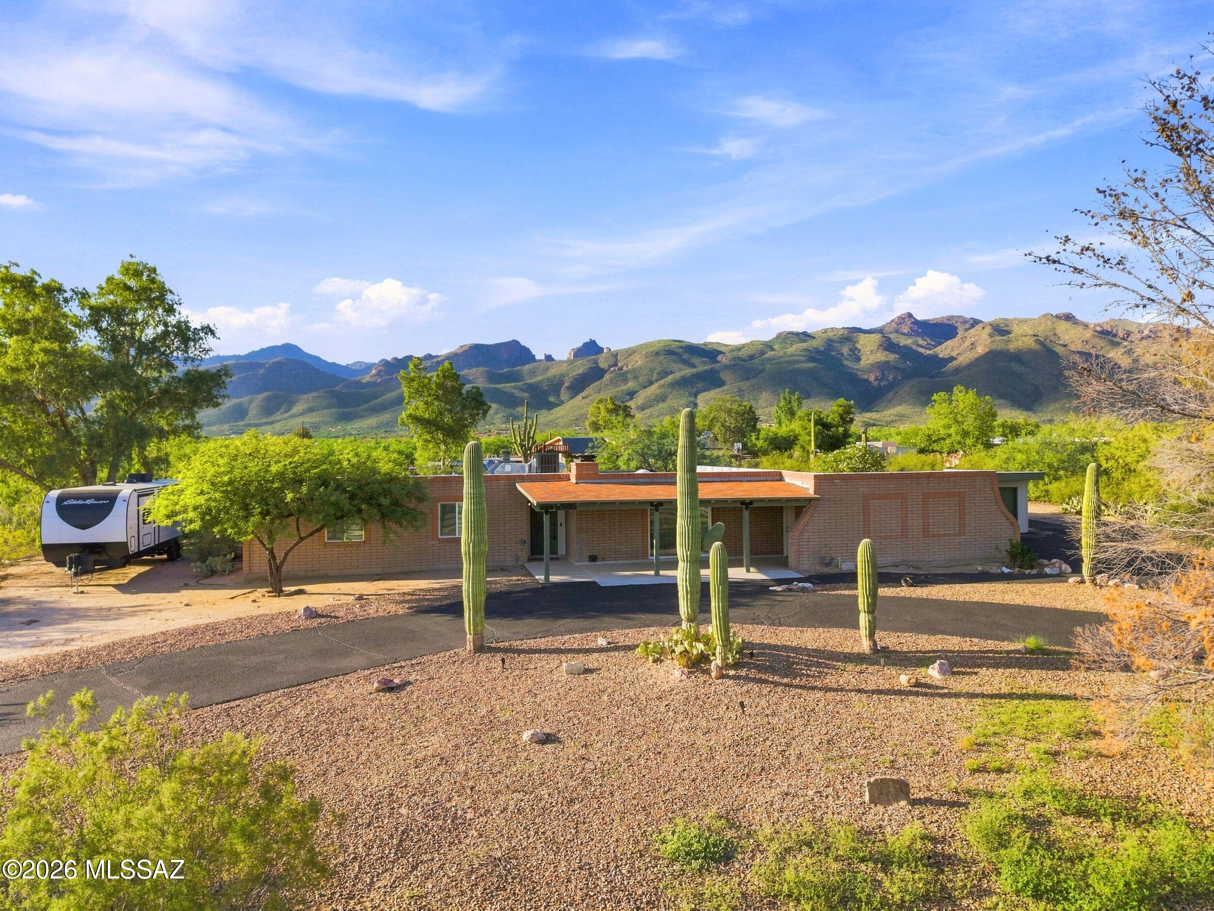 Situated on nearly an acre of land, this beautifully updated home captures breathtaking, unobstructed mountain views from nearly every angle. Intentionally 
designed for both comfortable living and effortless entertaining, the spacious floor plan offers flexible common areas, inviting fireplaces, and easy inside outside living. Step outside to your private backyard oasis featuring a newly resurfaced swimming pool, mature landscaping, and plenty of space in a desert landscape.
Enjoy the peace of mind that comes with a brand-new HVAC system, providing energy-efficient comfort year-round. The whole home has been meticulously remodeled with form and functionality in mind. The additions have the potential to be used in many ways. The theater room can be a 4th bedroom or the bedroom for a guest wing. The eastern living space off the kitchen can continue to be used as a home office and reception area, a homeschool pod, or a future guest wing. The possibilities are endless. Come. See. Stay!