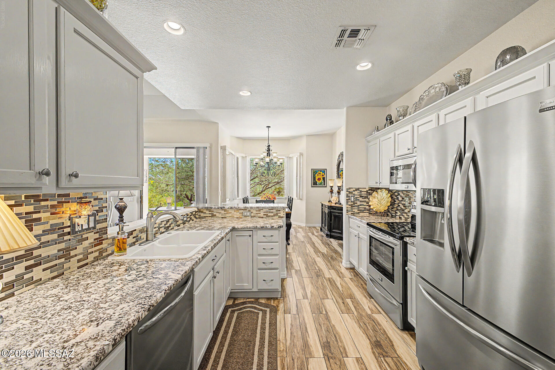 Impeccably maintained and truly move-in ready, this updated home in gated active adult 55+ Vistoso Village offers the effortless lock-and-leave lifestyle buyers love. The desirable split floor plan and thoughtful upgrades throughout set this home apart. Enjoy an updated kitchen and baths, an epoxy-coated garage floor with built-in storage, a 4' garage extension, and a private patio featuring a tranquil fountain and retractable solar screens for year-round enjoyment. The HOA fee delivers exceptional value by covering many of the expenses homeowners typically pay separately, including water, sewer, trash/recycling, cable & internet, landscaping, roof repair/replacement, exterior paint & maintenance, street maintenance, termite treatment, pest control, gated entry, heated pools & spa, fitness center, clubhouse, library, billiards, card/crafts room, media room, BBQ areas, and year-round clubs and social activities. It's a lifestyle designed for convenience, peace of mind, and low-maintenance living!