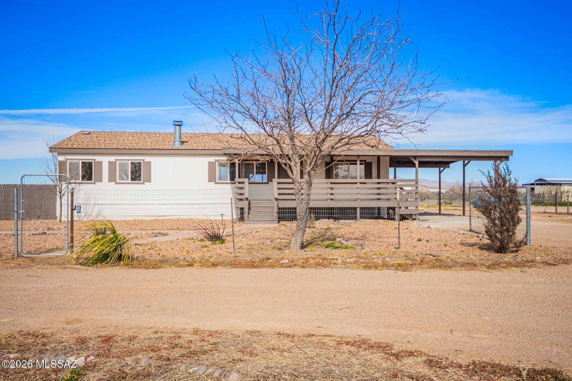 Now Available! Updated manufactured home situated on over a 5 acre lot. Recent upgrades include luxury plank flooring, new carpet and pad, updated electrical fixtures, door hardware, and a brand-new AC.  Kitchen features crisp white cabinets, new countertops, and stainless steel appliances. Interior and exterior updated with fresh paint. Large deck for taking in the beautiful Arizona sunsets. Move-in ready and a must see!