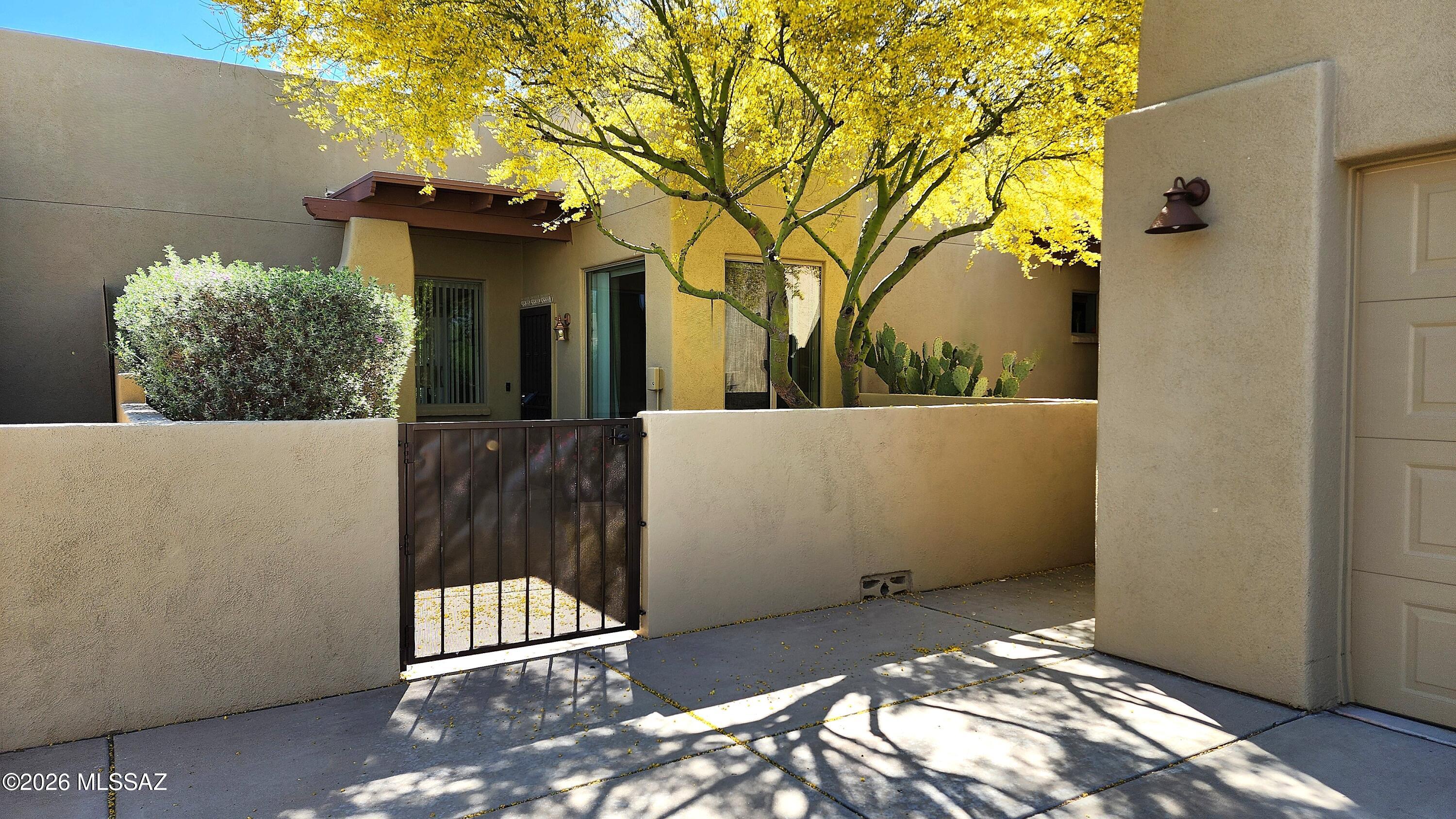 This specious townhouse features high ceilings and new tile floors throughout.  Entry courtyard with gate, plus a covered back patio with fantastic wide open views of the Rincon mountains and Sahuaro park.  Super quiet and picturesque location.  Fresh paint inside and out, newer shower that's also roll in, one car garage, washer and dryer, and masonry construction that makes it super quiet inside.  Single story, and just 4 townhomes on this amazing elevated site.  Located on highly desirable Carver Lane, this property is exceptionally quiet and tucked away from the main roads.  This is a 55+ community.