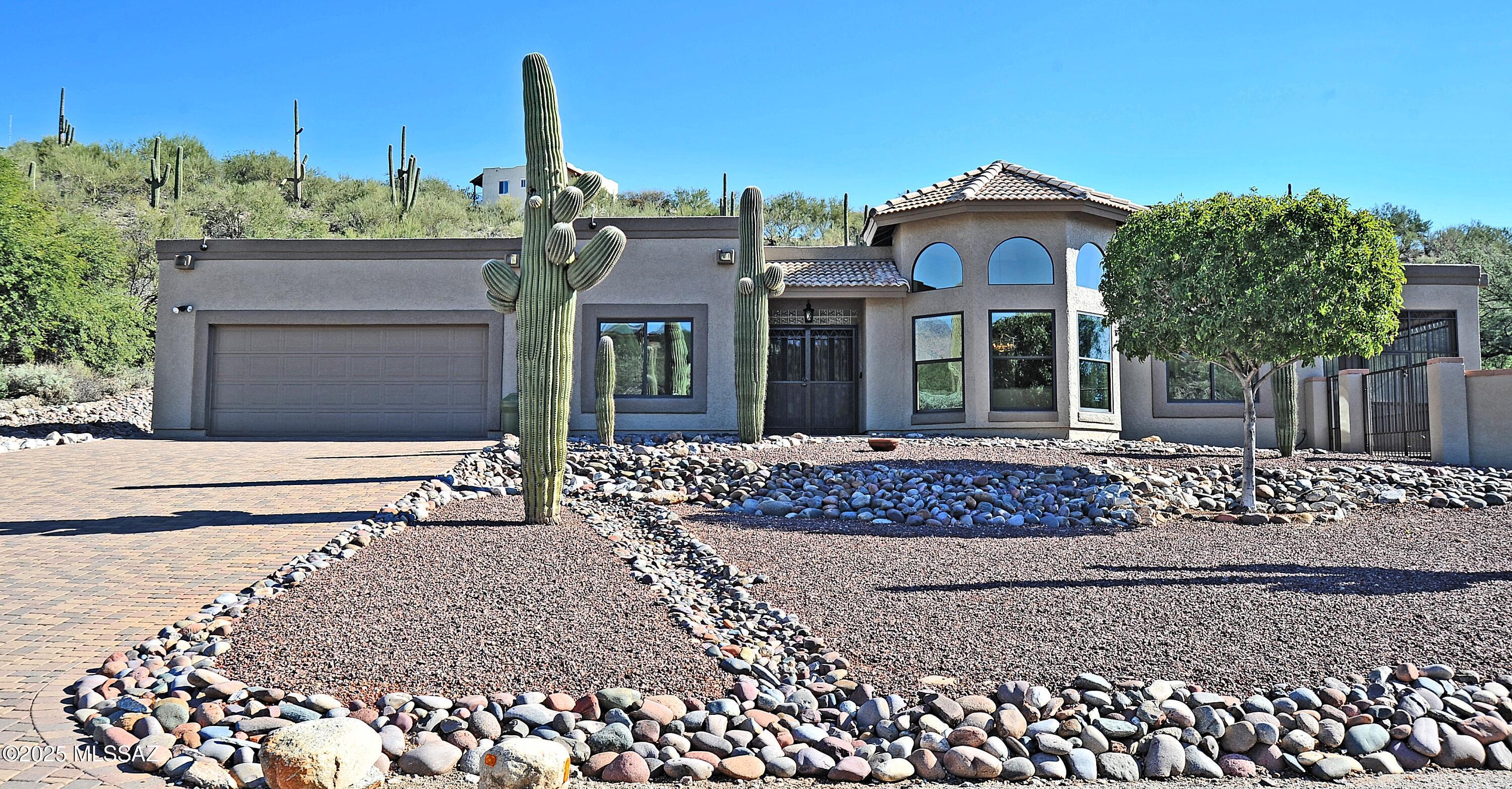 Experience true Catalina Foothills living in this beautifully updated home situated on over 1.28 acres, just minutes from world-class resorts, shopping, dining, hospitals, golf, biking, and hiking. The inviting floorplan offers exceptional flexibility, featuring an open kitchen connected to two separate family/living areas, a formal dining room, an additional breakfast area, an Arizona room for year-round enjoyment, and a desirable split-bedroom layout. A stunning two-way fireplace sits between the main living spaces, creating warmth, ambiance, and a natural gathering point for entertaining or relaxing evenings at home. The chef's kitchen has been thoughtfully remodeled with gorgeous granite countertops, a custom matching granite sink and lazy Susan, upgraded cabinetry with soft-close doors and pull-out drawers, GE Profile stainless appliances including an induction cooktop, built-in double ovens, a pop-up stove vent, and full granite backsplash extending to the upper cabinets. Everywhere you turn, this home shows pride of ownership, from the Delta fixtures with lifetime warranty to the upgraded interior Sherwin-Williams Emerald paint, custom skylight diffusers, and high-efficiency, theft-resistant windows installed just two years ago.

Incredible sunrises and sunsets.
Both indoor and outdoor spaces have been meticulously maintained. The home is equipped with Hunter Douglas Duette bottom-up insulating blinds and vertical glides, wrought-iron security screen doors, a newer garage opener, a top-of-the-line WaterTec softener, reverse osmosis system, enhanced water heater, and PVC irrigation lines throughout the property. Seven Exterior security system for added "peace of mind". The exterior is equally impressive with a Belgard paver driveway, walkways, and patios (all under lifetime warranty), manicured low maintenance landscaping with numerous saguaros, decorative stone, multiple fruit trees, and a private backyard enclosed by a block and privacy wall.

Relax on the spacious patios one, fully screened in with wrought iron and the other enclosed with a three-foot wrought iron fence perfect for enjoying the desert scenery and evening breezes. A long paver driveway easily accommodates multiple guests, making this home ideal for gatherings and everyday convenience.

This Foothills gem blends thoughtful upgrades, careful maintenance, and a highly functional layout to create a truly exceptional living experience. Homes with this level of quality and setting are rare. Don't miss this opportunity to make it yours