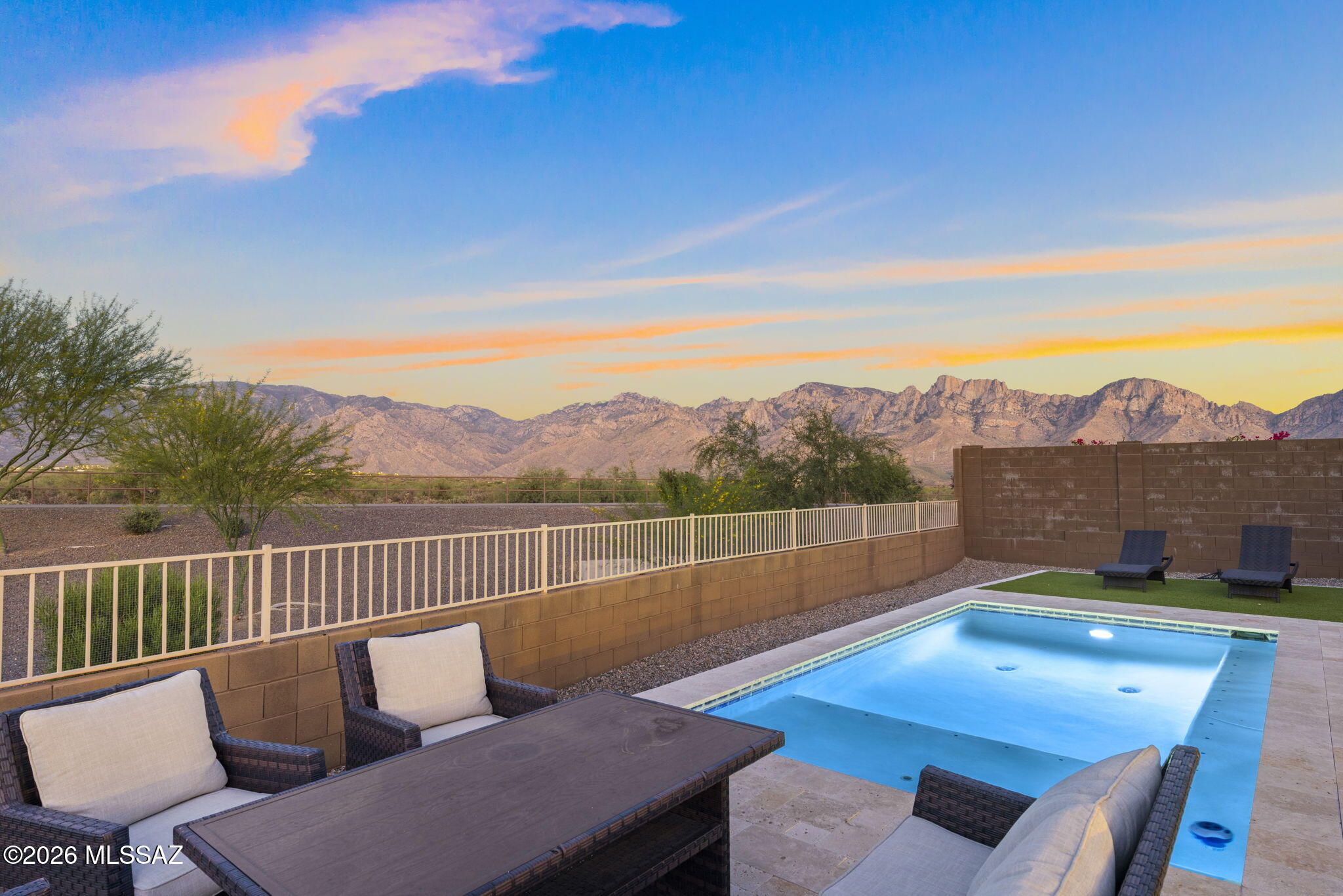 Unobstructed Catalina Mountain views, an oversized lot, and a pool already done. This Oro Valley gem has it all. The open kitchen impresses with dark espresso cabinetry, gold hardware, a granite waterfall island, double wall ovens, and a 36'' gas cooktop. The private den features rich sage green accent walls, built-in shelving, French doors, and a statement chandelier, perfect for a home office or creative space. The primary suite features a spa-like bath with a double vanity, stunning walk-in shower, and a large walk-in closet. Out back, a covered patio with string lights overlooks a sparkling pool, turf lounge area, and fire pit seating, all framed by breathtaking Catalina Mountain views. This one truly checks every box.