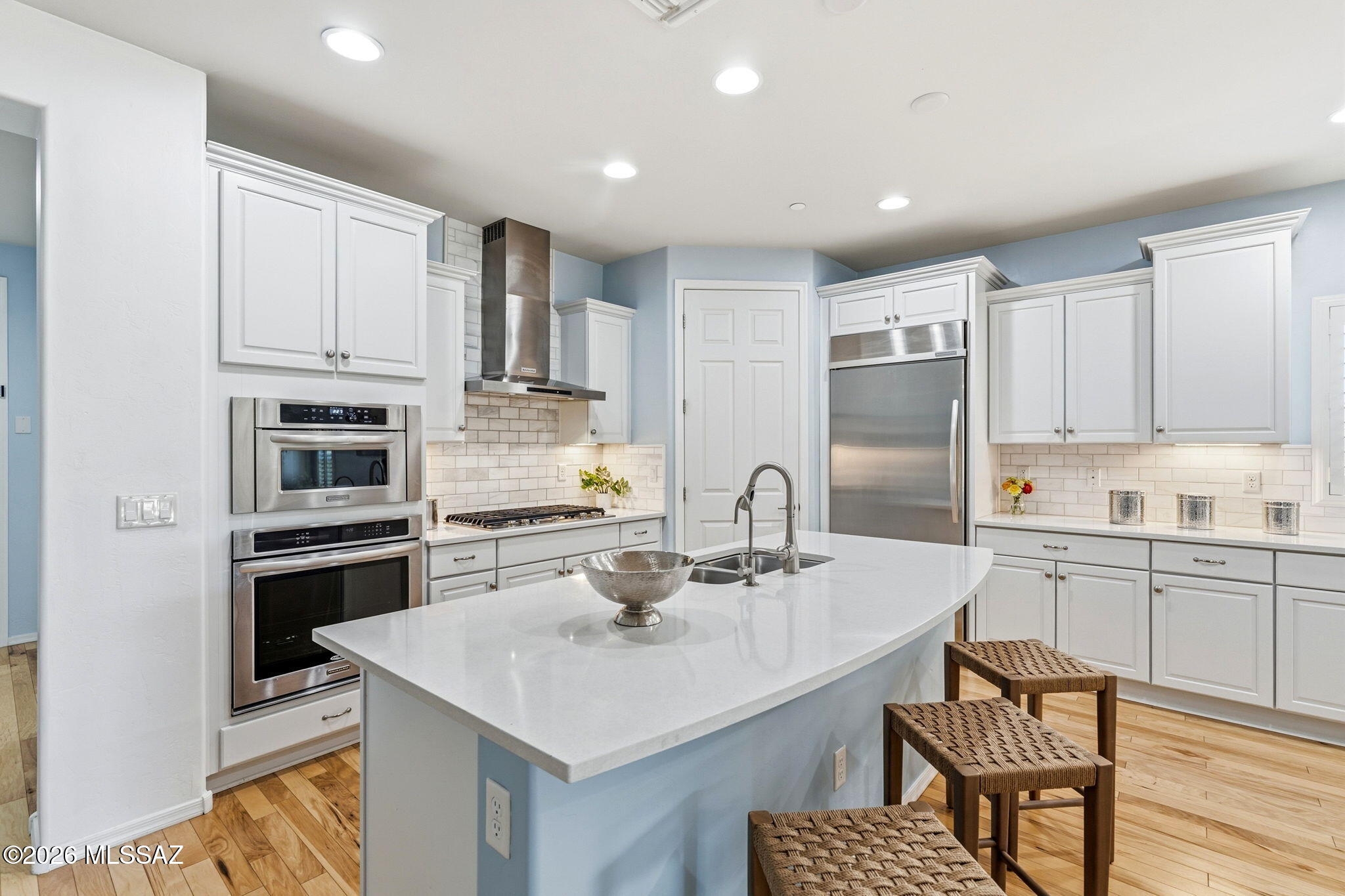 Seller will accept offers ranging from $550,000 - $565,000. Experience refined Sonoran living in this impeccably upgraded 4 bed/2 bath home with a dedicated front office. Situated in a quiet NW enclave on a private lot w/no neighbors to one side, this home borders a manicured common area for tranquility. Inside, high ceilings & rich hickory wood flooring set a sophisticated tone thru-out an expansive great room layout built for entertaining. Chef's gourmet kitchen w/quartz counters accented by custom designer tile backsplash, 5-burner gas cooktop, built-in wine fridge, SS appls & under cabinet lighting Desirable split bedroom floor plan ensuring primary suite privacy. Custom window shutters thru-out bedrooms. Located iin a boutique neighborhood enclave just minutes from the new mall, shopping, destination dining, premier golf, medical & more