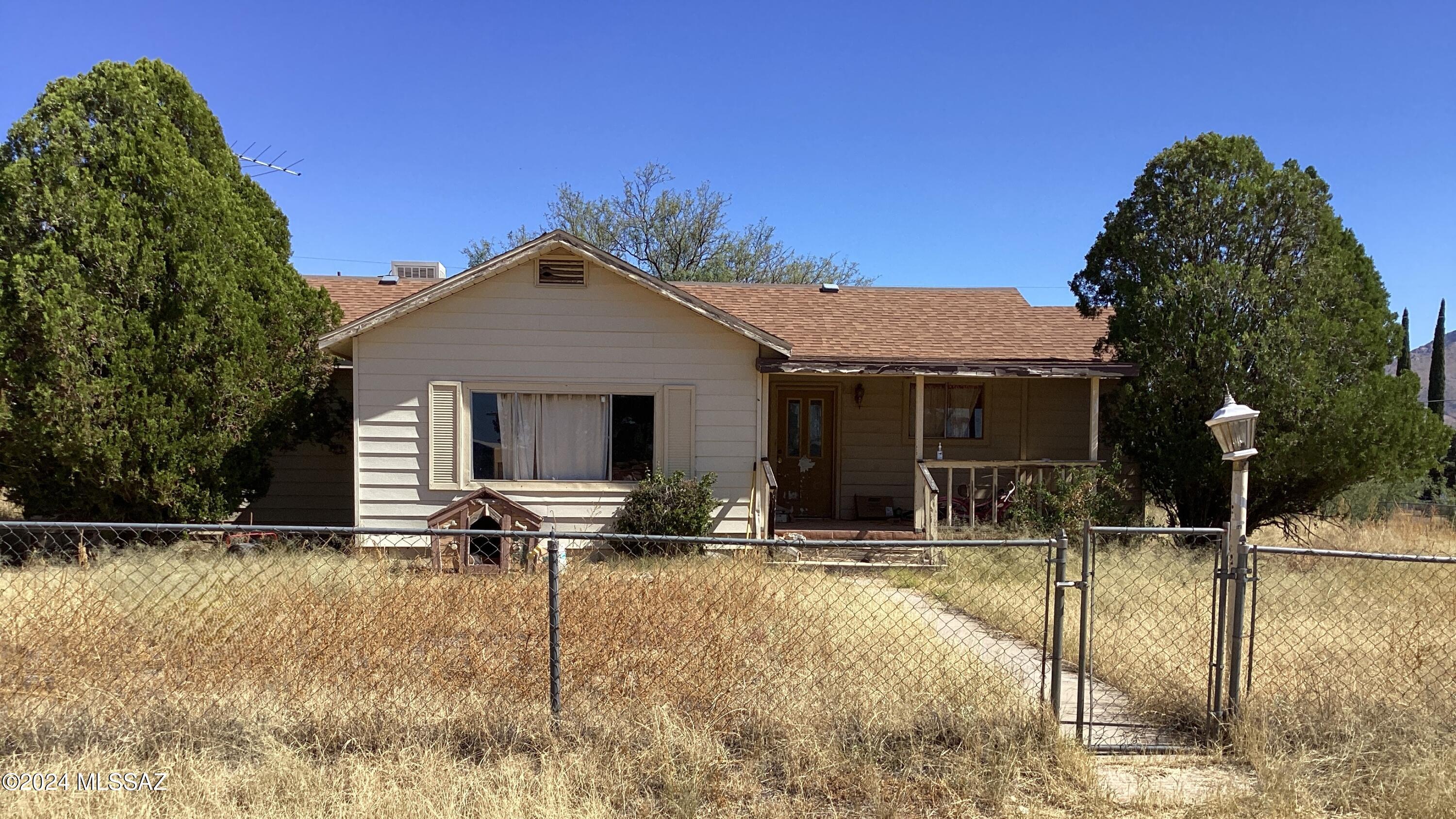 This is a 1564' 2-bedroom, 2-bath with den fixer-upper that sits on a .38-acre corner lot & is being sold ''As Is''.  Nice front covered porch leads you into the spacious foyer, living room, dining & a pass-through window to the kitchen. The den is off the kitchen & has a split bedroom plan. Primary has its own sitting area, bathroom, walk-in closet, dressing room & access to the backyard. On the opposite end is a bedroom, guest bath & laundry room with back door. There is an existing shed & out-building on the property & room for RV Parking through the double gate in the chain link fence that is completely around the entire property.  This house is ready for its new vision to be put into reality and become someone's home. Come on out & see for yourself what this property has to offer.