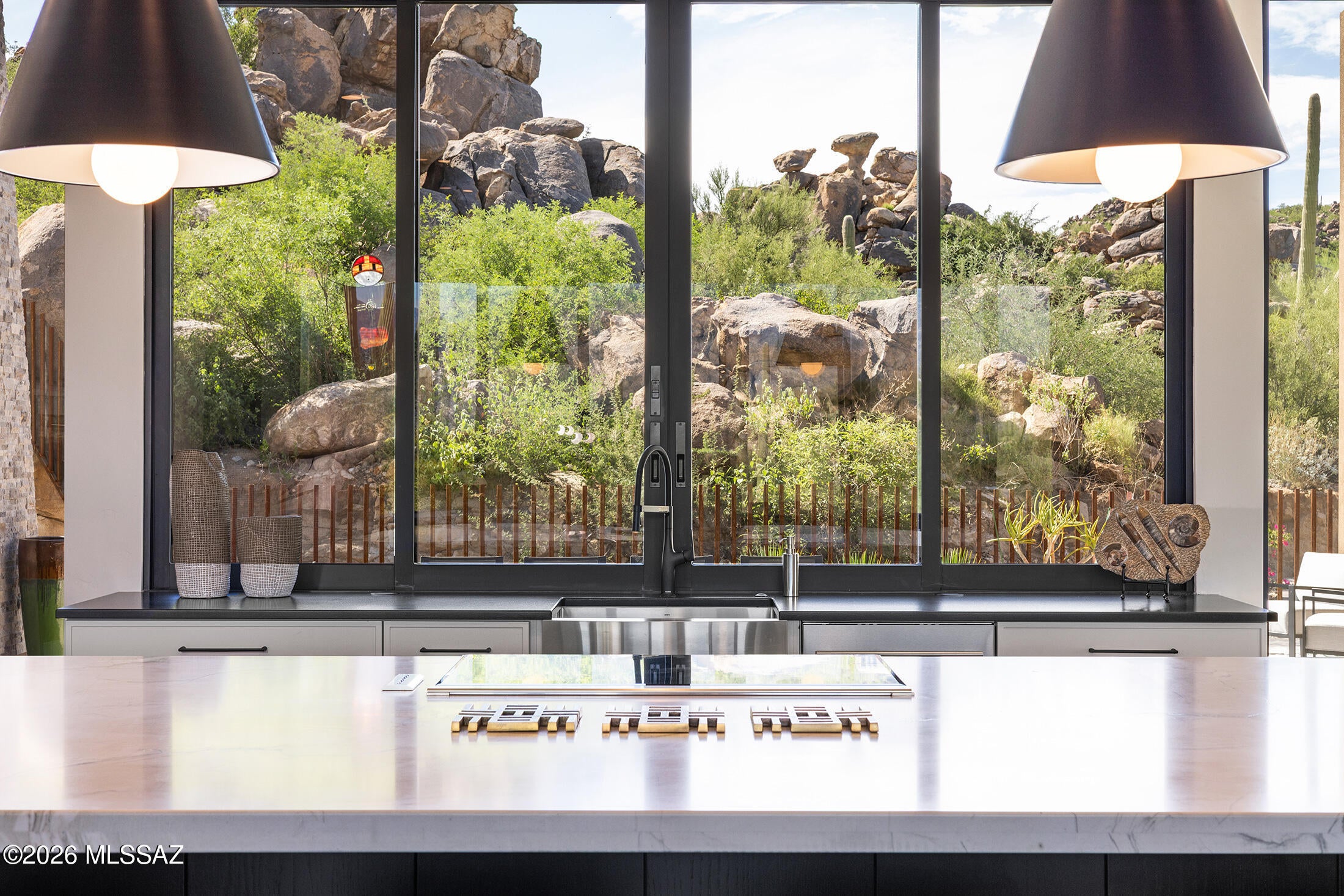 A striking expression of modern desert living. 
This custom residence is being offered fully furnished and feels virtually new.  Thoughtfully designed around its dramatic natural settings, this home is nestled among impressive rock formations and elevated to capture sweeping Catalina Mountain views. 
Walls of glass and expansive sliders connect the spacious great room to the outdoors, while the kitchen opens to an intimate courtyard with a passthrough bar- perfect for effortless indoor- outdoor entertainment.  The kitchen is anchored by a stunning Mont Blanc honed quartzite double-waterfall island and features Wolf induction cooking and steam oven, panel-front Sub-Zero refrigeration and a butler's pantry.   
The main residence offers three en-suite bedrooms plus an office in a functional split floor plan. The primary suite features patio access and a spa-inspired bath with an oversized walk-in shower, soaking tub, dual vanity, skylights and two large custom closets. 
Large format tile flows throughout the main living areas with engineered wood flooring softening the bedrooms. 
A private 625 sq ft guest house offers a spacious and inviting retreat with its own separate entrance- thoughtfully positioned for privacy.  It's an ideal setting for weekend guests, extended family, or a comfortable mother-in-law suite- providing the perfect blend of independence and connection to the main residence.  
This beautiful home is within the premier gated community of Stone Canyon in Oro Valley, an exceptional residence  that offers a rare combination of architectural sophistication, privacy and breathtaking Sonoran Desert beauty.  Surrounded by dramatic boulders, towering saguaros and the Catalina Mountains.  It's an extraordinary opportunity to experience refined desert living in one of Southern Arizona's most sought-after communities.