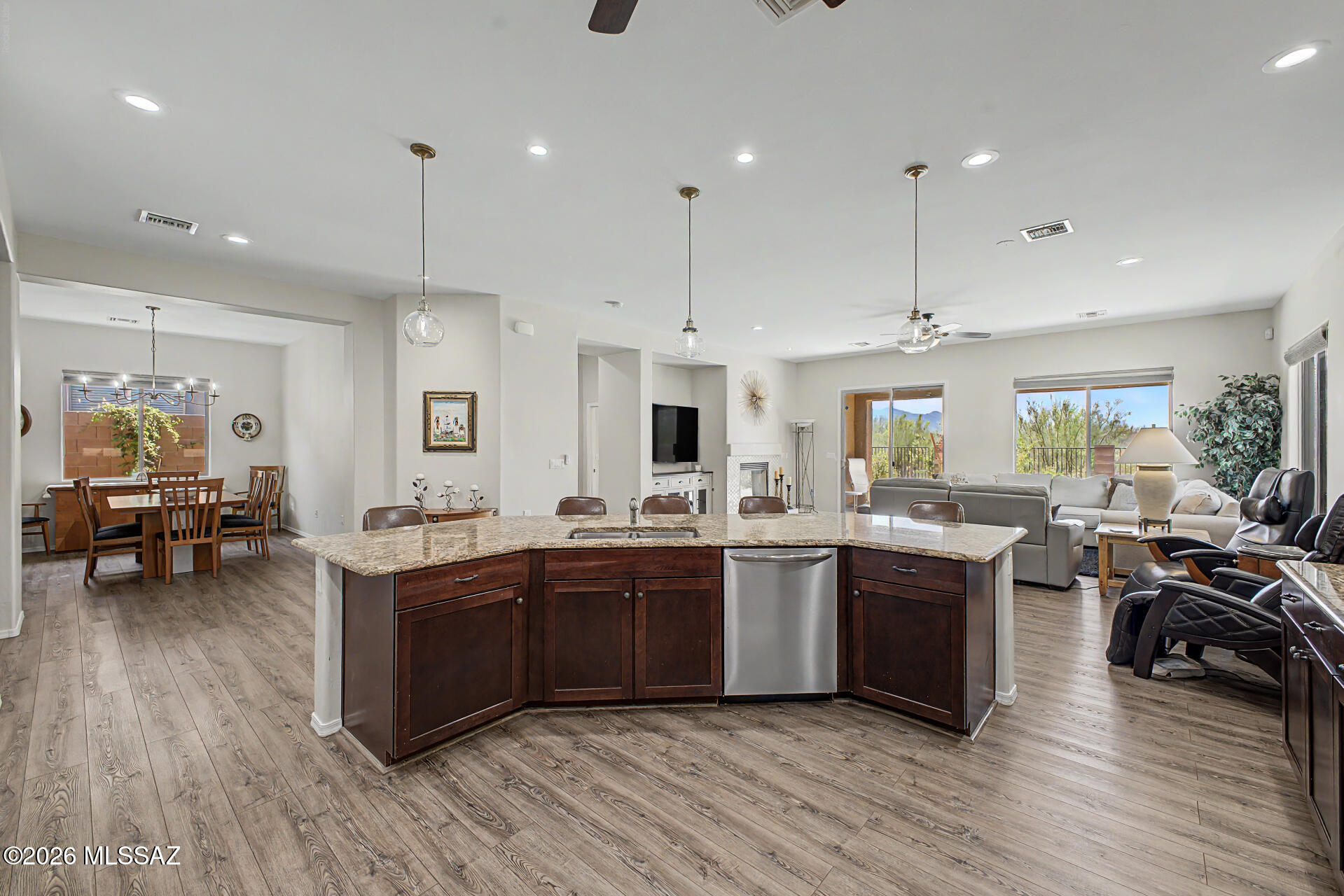 3D Matterport & Floor Plan available Call Listing Agent For Details The search is over! This lovely 4-bedroom residence welcomes you w/ a 2-car garage, a charming desert landscape, & tasteful stone accents. Fall in love w/ the captivating open layout featuring high ceilings, a soothing palette, wood-look flooring, & an inviting fireplace. The formal dining room is perfect for unforgettable dinner gatherings. Cook delicious meals in the gourmet kitchen, equipped w/ granite counters, ample wood cabinetry w/ crown moulding, pendant/recessed lighting, a mosaic tile backsplash, stainless steel appliances, a pantry, & an island w/ a breakfast bar. The primary bedroom showcases soft carpeting, direct backyard access, an ensuite w/ dual sinks, & a walk-in closet.
