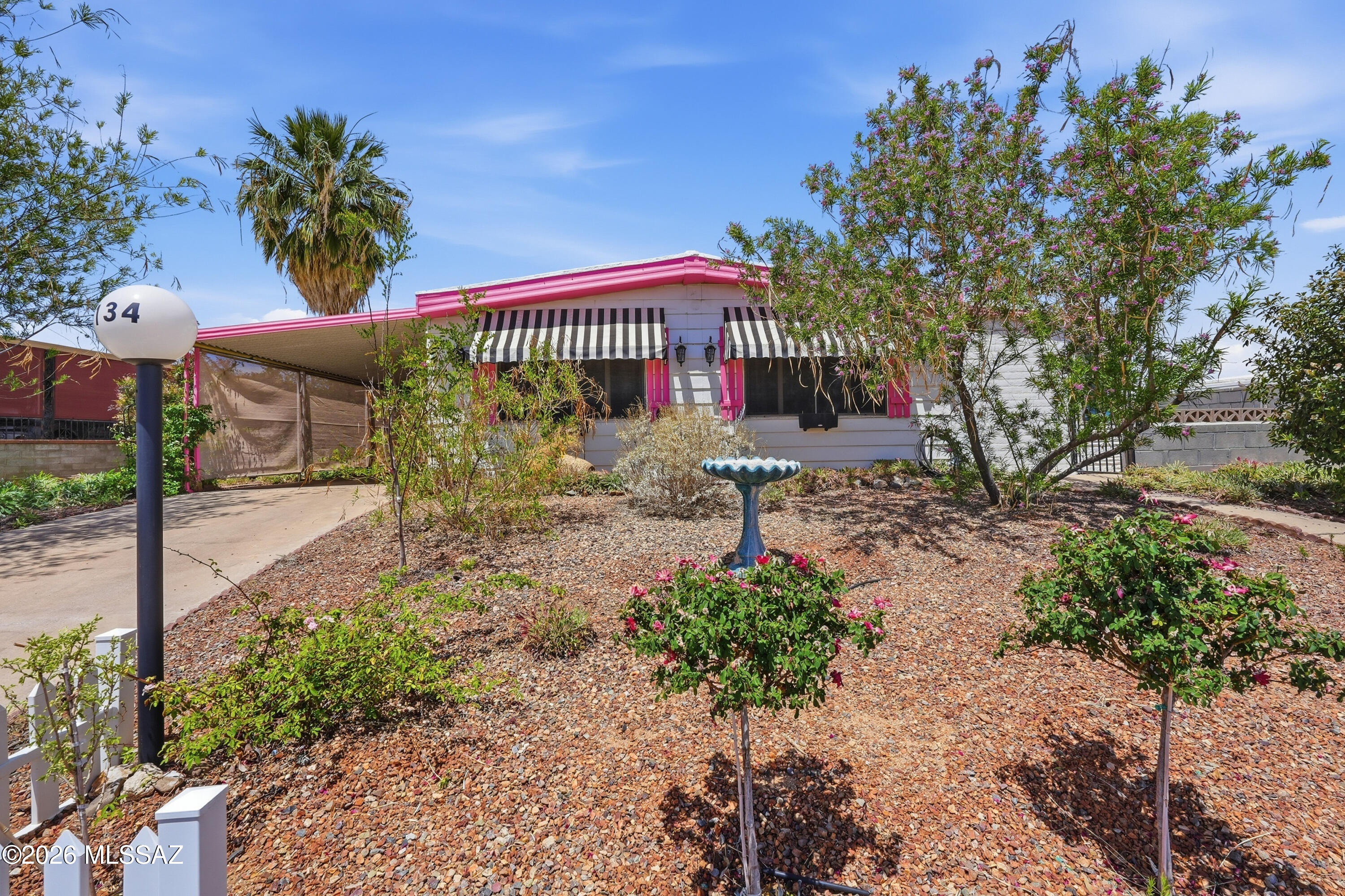 LOCATION! LOCATION! LOCATION! This charming 2-bed, 2-bath home sits directly across from the community clubhouse and pool the in desirable Green Valley Mobile Estates. Enjoy beautiful mountain views from the front of the home and fresh curb appeal with new front-yard landscaping. Inside, you'll find new tile flooring, a bright living area, and a functional kitchen with gas range and pantry. The Arizona room and bonus den/office are enhanced with new mini splits, while the home also features a new massive heat pump, new water heater, water softener, and a TV that conveys. The fenced yard includes a storage shed for added convenience. A fantastic opportunity in an age-restricted community with optional GVR available.