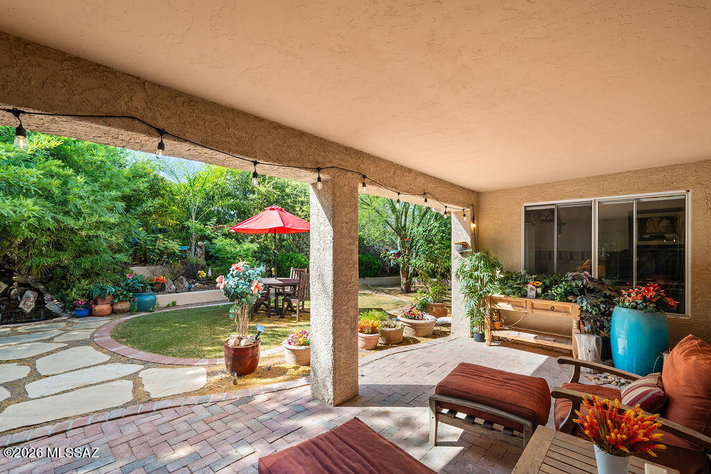 Welcome to your own private retreat in the highly sought-after 55+ community of Quail Creek! The true highlight of this home is the exceptionally private backyard oasis featuring mature shade trees, a tranquil koi pond water feature, and the perfect setting for bird watching, relaxing, or quiet meditation. Enjoy Arizona living year-round from the screened-in Arizona room that opens to a covered patio with pavers, flagstone, artificial turf, and beautifully designed outdoor spaces perfect for entertaining. The enclosed front courtyard with flagstone adds even more charm and privacy. Inside, this beautifully maintained home is filled with natural light from an abundance of large windows and offers soaring ceilings, no carpet, and two spacious living areas designed for both comfort and entertaining. The kitchen features granite countertops, while the primary suite includes a charming bay window overlooking the peaceful backyard. An extended garage with a utility sink and extra storage cabinets completes this incredible home.