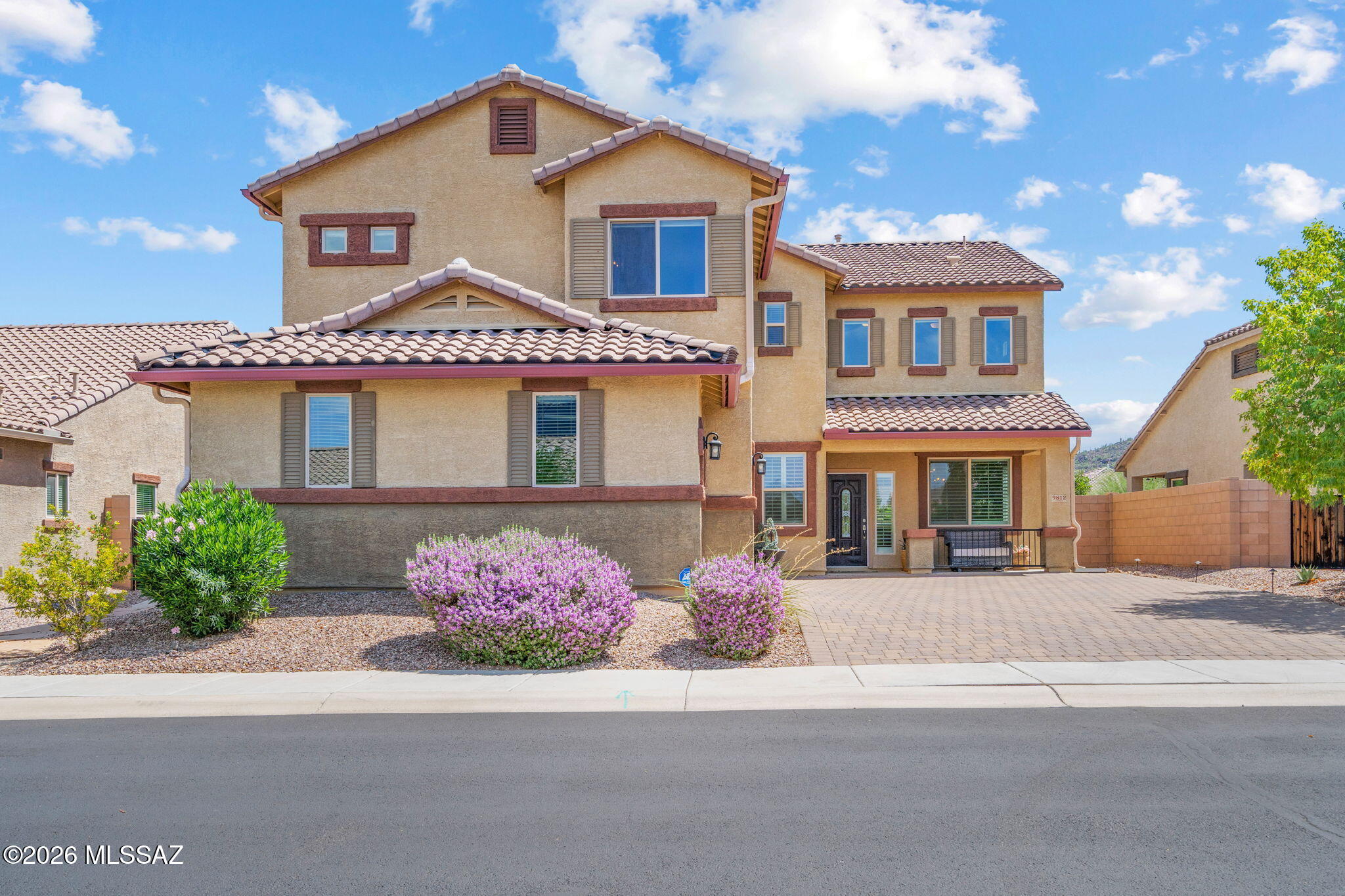 Embrace Sonoran Desert living in Marana's Saguaro Bloom neighborhood. This 2,968-square-foot home combines functional space with low-maintenance desert living. The main level offers a dedicated office, leading into a light-filled living area with soaring double-height ceilings and views of the surrounding desert skies.

The kitchen is designed for entertaining, with a granite island, gas range, walk-in pantry, and stainless steel appliances. Upstairs, a central loft serves as a second lounge or play space.

The primary suite features a double-sink vanity, soaking tub, and separate walk-in shower, with three additional secondary bedrooms. Out back, relax under the covered patio and take in Tucson mountain views over low-care landscaping. Block wall privacy and a paved driveway leading to a three-car garage round out the home. Enjoy Saguaro Bloom's community pool, clubhouse, parks, and basketball courts, all set against the Tortolita and Tucson mountain backdrops.