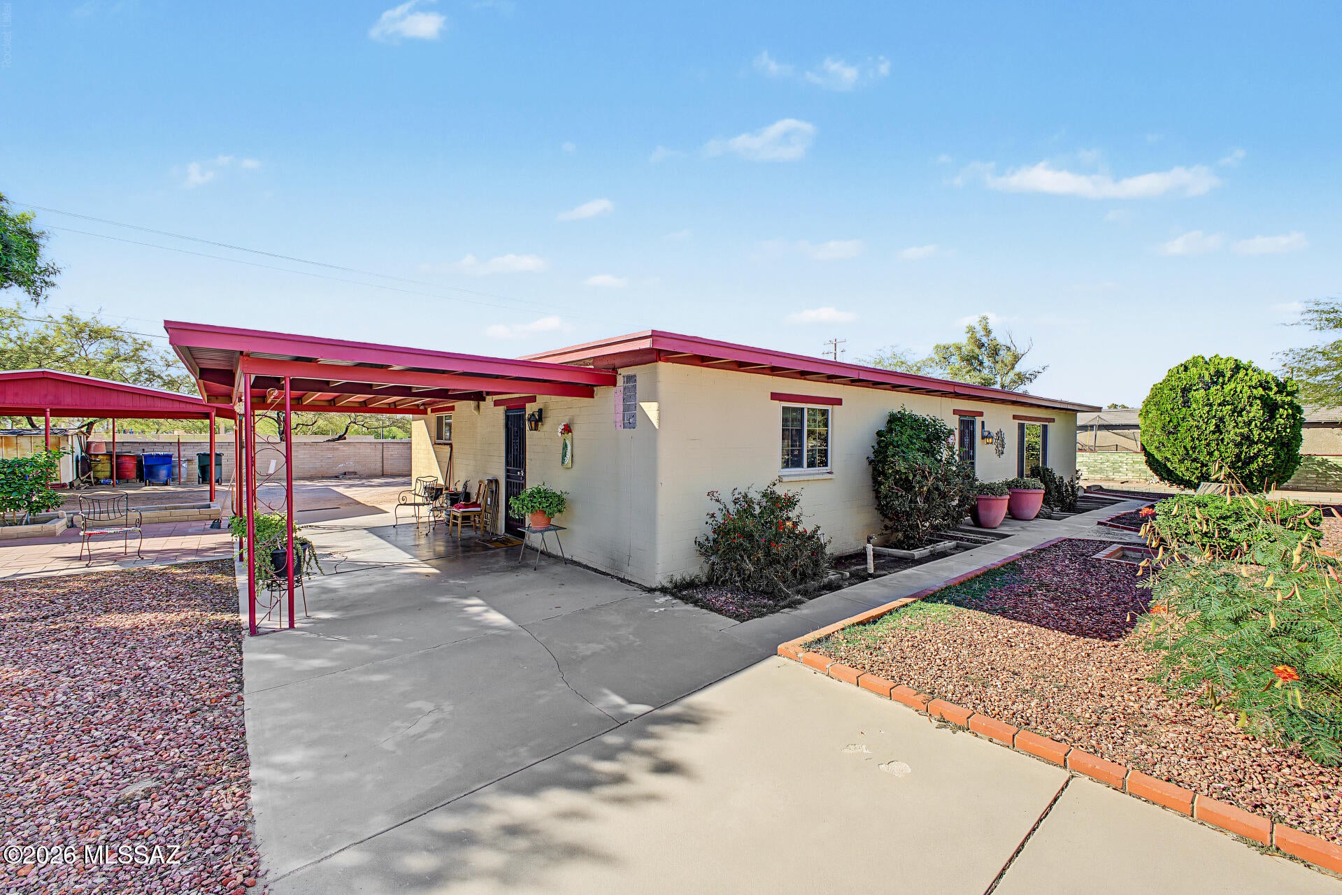 Welcome home to this 2 bed, 2 bath home with den! A gated courtyard entry and desert landscaping lead inside, where a wood-beamed ceiling and plantation shutters warm the living room and arched openings flow into the dining area. The oversized kitchen offers abundant oak cabinetry, a breakfast bar, eat-in space, recessed lighting, and stainless appliances including a gas range. The primary suite features a full wall of built-in storage. Then step out back and the yard steals the show: an expansive block-walled lot with room to park vehicles and toys, garden, or build the workshop you've always wanted. A detached block outbuilding, a roll-up door garage/shop, and three covered carports make this a true blank canvas. Bring your vision!