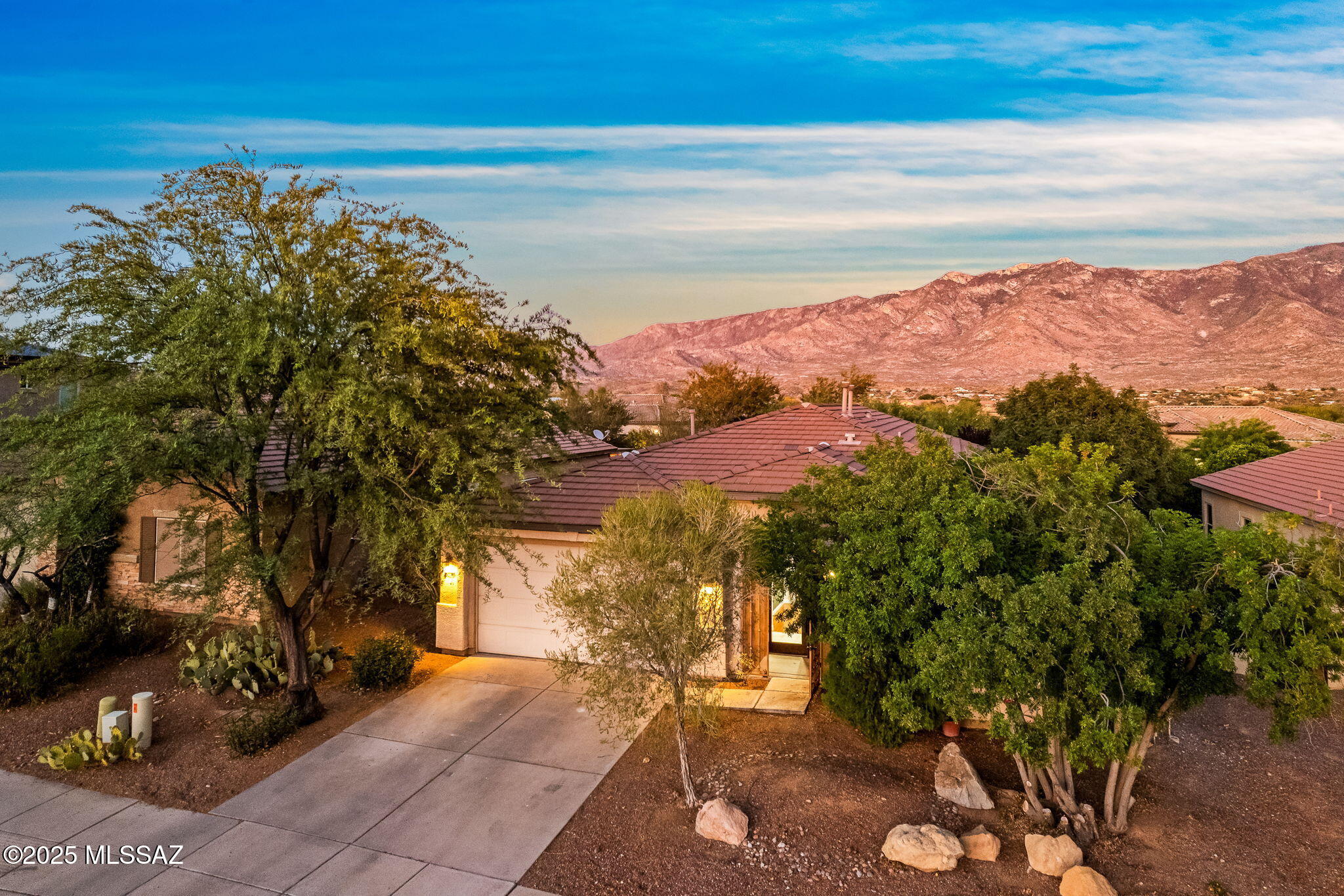 Breathtaking Catalina Mountain views take center stage at this spacious 3-bedroom, 2.5-bath home near Oro Valley and Catalina State Park. A custom wrought-iron entry door welcomes you into a thoughtfully designed split-bedroom floor plan with 9-foot ceilings and laminate and tile flooring throughout the main living areas. The open family room connects seamlessly to the kitchen, featuring granite countertops, island, cherry cabinetry with crown molding, a gas cooktop, double ovens, and SS appliances. The sprawling primary suite offers beautiful mountain views and two generous closets. Step outside to a covered patio and an extended brick-paver patio spanning the entire length of the home, offering plenty of space to relax or entertain against a the mountain backdrop complete w/ fruit trees.