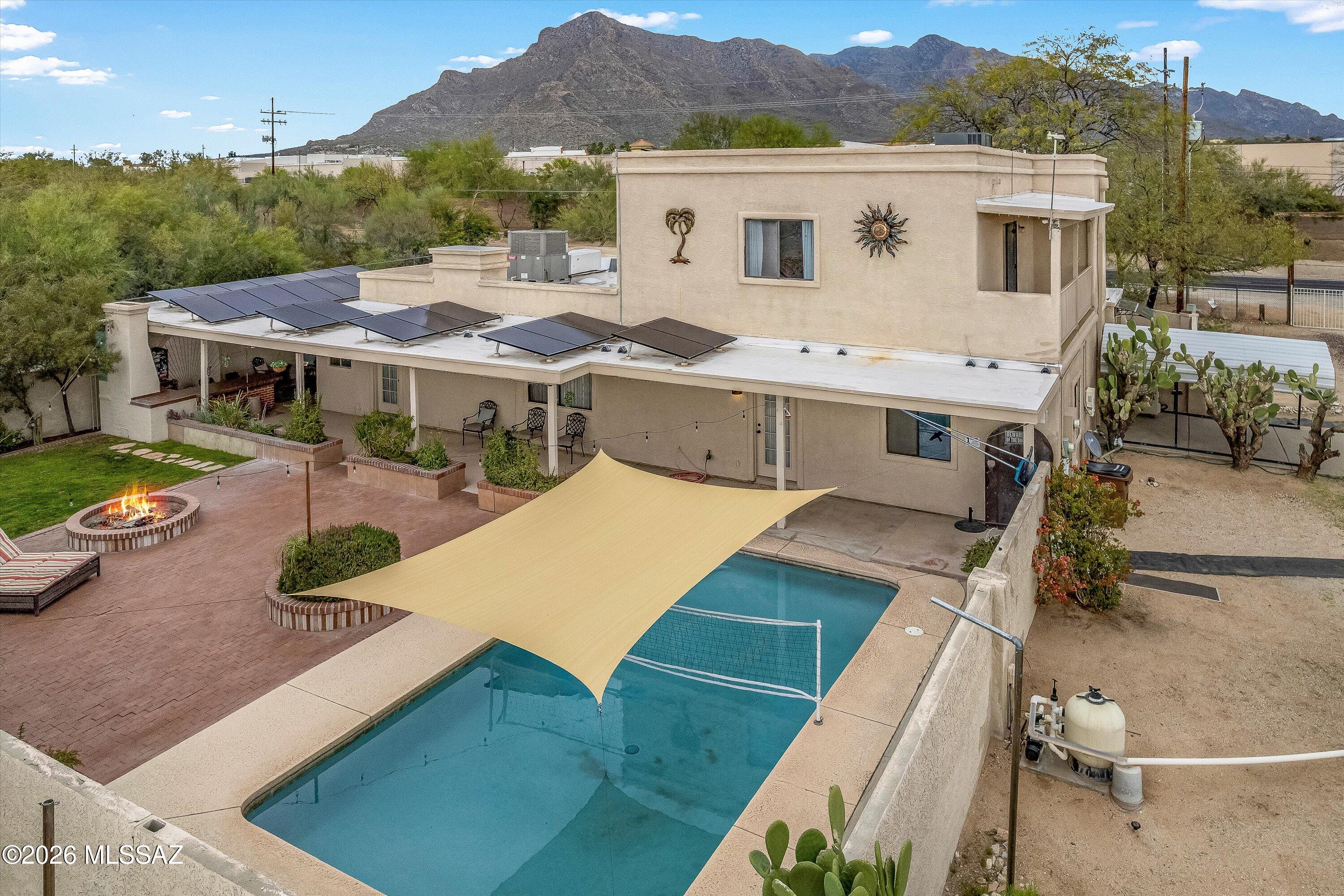 Rare Casas Adobes acre property with no HOA, pool, guest quarters, and fully paid solar; walkable to restaurants, shopping, and the beloved Tohono Chul Park.  This home features a versatile floor plan with attached guest quarters ideal for multi-generational living, visitors, a private office or a rental property. The entire second floor is a spacious ~950 sq ft primary retreat, creating a private, spa-like escape. Enjoy the backyard with sparkling pool, extended covered porch with built in bar and fireplace and room to spread out. Horse privileges allowed by zoning and nearly 1/2 acre of flat, usable space for additional outdoor living, toys or income potential. Fully paid solar keeps utility bills low. A rare opportunity to enjoy acre living in the heart of 85704.