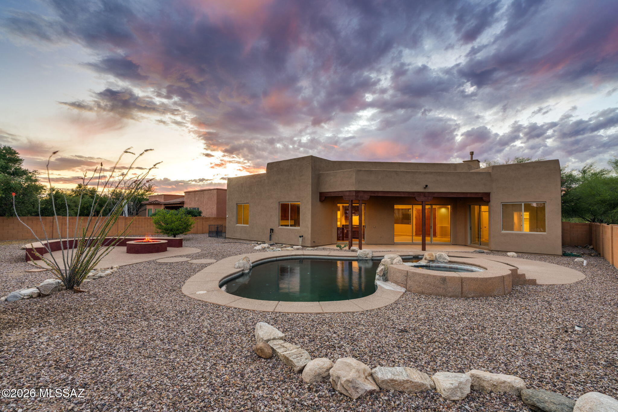 The backyard of your dreams! Located in the gated Sycamore Canyon on a large corner lot. Immediately recognize the quality construction by the local builder, Pepper Viner. Beautiful curb appeal with a mature shade tree and a Saguaro. A welcoming front courtyard leads to French front doors. Inside, a large great room features soaring ceilings, natural light and a wall of sliding doors to the backyard. The chef's kitchen is well appointed with direct access to the back patio, warm cabinetry, pull-outs, stainless steel appliances, gas cooktop, wall oven, bar seating, pantry, and an island with outlets. A split floorplan creates a private primary suite with direct access to the backyard. The primary bathroom offers dual sinks, a makeup vanity counter, a soaking tub, and a large walk-in closet. A rare extended-length 3-car garage has epoxy flooring and a pedestrian door to the backyard.The private backyard backs to open desert. A stunning pebble tech pool and elevated spa feature rock accents. A built-in gas fire pit with expansive bench seating is perfect for hosting.New interior paint and carpet throughout, with the roof recoated in October 2025. Completely move-in ready! Located in the desirable Vail School District.