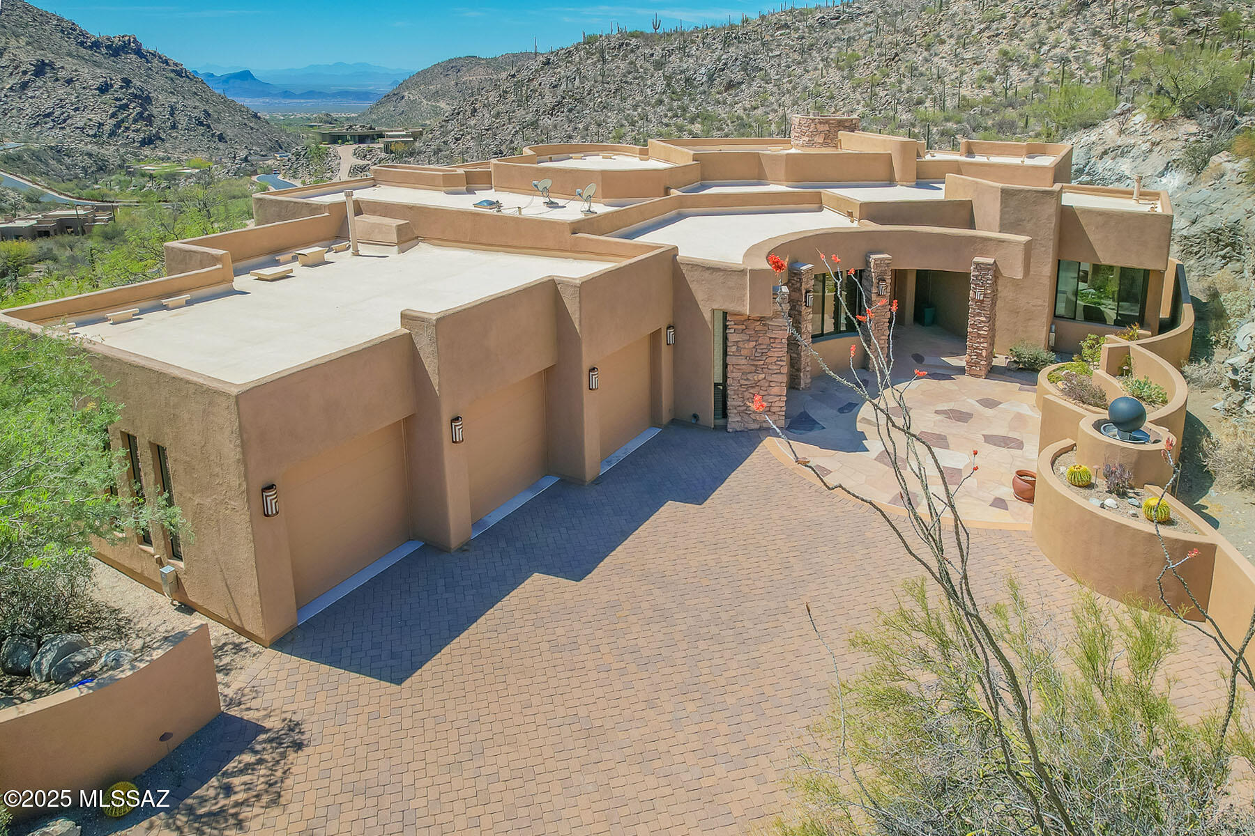 LUXURIOUS CUSTOM ESTATE designed by award-winning architect, Kevin Howard. This private estate sits high nestled against the Tortolita Mountains in the exclusive, guard gated community of Canyon Pass at Dove Mountain. Enjoy breathtaking panoramic views of the canyon, valley and mountains beyond... plus a sparkling, heated pool. Gated drive winds to a flagstone patio entrance with orbital water fountain. This 3,665 sq ft residence affords 4 bedrooms and 4 full baths plus den/office. Large gathering room greets you with soaring ceilings, wall-to-wall view windows, corner stacked stone fireplace and custom art/media center. Formal dining area with views lies off a gourmet kitchen offering large island with prep sink, granite slab countertops, stainless/black appliances, built-in workstation and pantry, plus wood paneled Sub-Zero refrigerator/freezer, Dacor microwave and Asko dishwasher. Elegant Owner's suite accesses rear patio and hosts a stacked stone fireplace and luxury bath with granite covered vanity, jetted tub, circular tiled walk-in shower plus dual walk-in closets. Bedrooms 2 & 3 offer luxury en suite baths. Bedroom 4 lies off hall bath. Other luxury amenities include flagstone flooring, alderwood cabinets, curved walls & windows, stacked stone outdoor columns & interior accents, custom closets, skylights, art niches, recessed ceilings & clerestory windows. Extended laundry with sink, zoned heating/cooling and water heaters, plus 3-car extended garage with customized storage room. Security features include gated driveway, alarm and fire suppression. Retreat to a spectacular rear oasis with flagstone patio accents, wrought iron view fence, heated pool with rock waterfall plus breathtaking panoramic views. Dove Mountain is home to the Ritz-Carlton Resort & Spa, Gallery Golf & Sports Club, Golf Club at Dove Mountain, plus sport parks and hiking/biking trails.