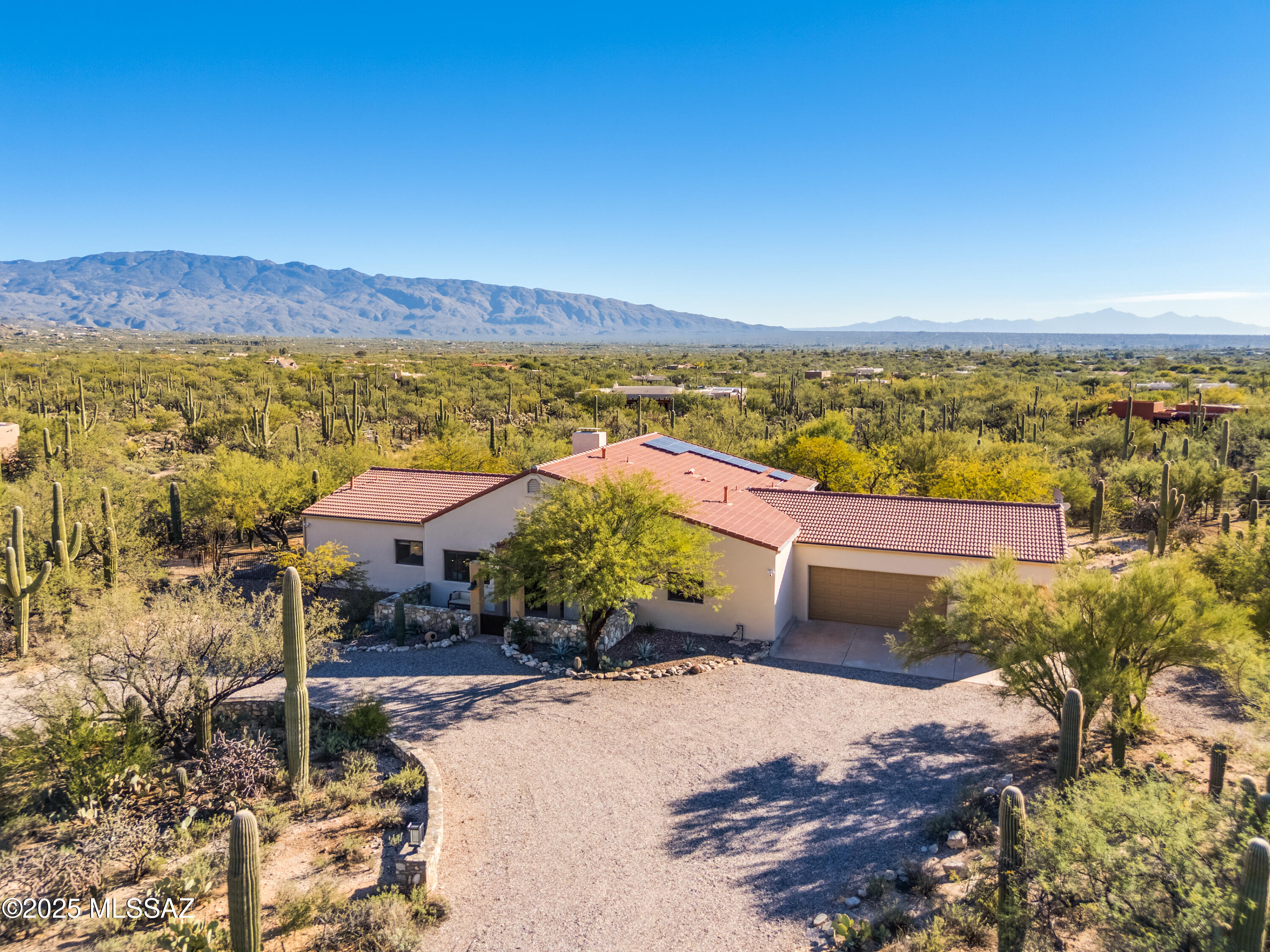 Owner/agent. Have you ever dreamed of living in a cactus forest surrounded by breathtaking mountain vistas? Sometimes dreams do come true! This meticulously maintained sanctuary spans over three acres of pristine desert landscape, nestled among majestic Saguaro cacti and mature mesquite trees in the highly acclaimed Tanque Verde School District. Arrive at the circular driveway and prepare to be amazed. From the front courtyard, take in the stunning views of the Santa Catalina Mountains before stepping inside a thoughtfully designed luxury retreat. The interior, designed and remodeled by Liz Ryan Design, blends timeless character with tasteful modern upgrades. High ceilings with exposed wooden beams, elegant ceramic tile flooring and custom window treatments create a warm, sophisticated ambience throughout. The award-winning chef's kitchen - recognized with second place in the Design Excellence Awards - features custom bamboo cabinetry by Affinity Kitchens, quartz countertops, a spacious central island with breakfast bar, and top-of-the-line stainless steel appliances including a gas cooktop and convection wall oven. A walk-in pantry with barn door entrance and a coffee / study bar overlooking the serene backyard complete the space. Open kitchen seamlessly transitions into an impressive great room with soaring ceilings embellished by massive wooden beams and monumental wood-burning fireplace, perfect for entertaining or intimate family time. The expansive primary suite, located at the end of the east wing, offers private access to the patio, pool and spa through French doors. Its gorgeous en suite bathroom features dual sinks, bamboo cabinetry, quartz countertops, designer mirrors and lighting, a luxurious walk-in shower and a custom walk-in closet. The east wing also includes a spacious second bedroom with walk-in closet and a versatile den/office/study, both with captivating mountain views. The west wing boasts two additional ample guest bedrooms with walk-in closets, full hall bathroom with large walk-in shower and a powder room, both with designer's touches. Step outside to an enormous covered patio with panoramic views of the Rincon Mountains. Enjoy evenings around the built-in firepit, relax in the sparkling saltwater heated pool and spa, or entertain in the outdoor kitchen and dining area featuring a built-in stainless steel BBQ beneath the shade of mature mesquite trees. An award-winning outdoor shower (third place in the Design Excellence Awards) adds a final touch of luxury. Exquisite laundry room features bamboo cabinets, stainless sink framed by a quartz countertop and high-end Electrolux front-load washer and dryer. Oversized three car garage and enormous storage / workshop / hobby room behind it will fit all your toys.  Sauna will be perfect for chilly winter nights. Picture-perfect 1 bedroom / 1 bathroom guest house built in 2023 is nothing short of amazing. Million-dollar views from the front porch and every room go hand in hand with refined, tastefully designed interior. The guest house currently is a successful, 5-star vacation rental, generating approximately $40,000 in annual passive income. It holds all Airbnb's accolades -  "Superhost", "Guest Favorite" and "Top 1%". Built in 2021, beautifully set horse facilities consist of two oversized 10' x 28', fully covered stalls with electricity, lighting, fans and water, hay barn, huge dividable turnout, hitching rail and more. Owned solar system covers nearly 100% of the property's electricity needs and professional water harvesting system provides enough water to keep your backyard oasis flourishing. Other recent improvements include replacement of the entire underlayment on the main house tile roof, exterior paint job, two new HVAC systems at the main house, central water softener and filtration system, pool replastered with PebbleTech and converted to saltwater system, new variable speed pool pump and wi-fi operated control panel, Ring security system at the main house, guest house and horse facilities, and more. Make sure to review the full list of nearly $350,000 latest property improvements (not counting the interior design and remodeling) available in the Documents section of the listing. Living in this scenic oasis feels like a permanent vacation in a national park - yet you're just minutes from shopping, dining, entertainment, healthcare and countless other services. Don't miss your chance to own this private piece of paradise!