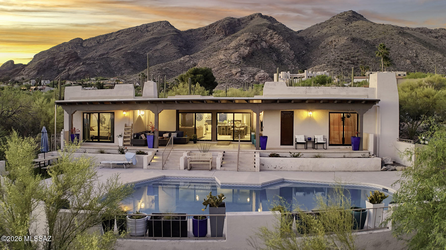 Located at the end of a quiet cul-de-sac on an elevated homesite within the prestigious, guard-gated Skyline Country Club Estates, this fully remodeled 1976, territorial-style residence showcases breathtaking, unobstructed 180-degree ''city lights to Mexico'' views across Tucson.  A welcoming front courtyard sets the stage with new travertine flooring, built-in BBQ, banco seating, firepit, and stunning Catalina Mountain vista, an ideal space for relaxing or entertaining.  Inside, the 2,378 sq. ft. great room floor plan offers 3 bedrooms and 3 baths, thoughtfully redesigned with new ceramic wood-plank flooring, exposed beamed ceilings, a charming beehive fireplace, and dramatic walls of glass framing the panoramic cityscape.  The gourmet kitchen is both stylish and functional, featuring an oversized center island, all-new cabinetry and countertops, stainless steel appliances, and a professional-grade gas range, perfect for everyday living or hosting.  The luxurious primary suite is a private retreat, complete with its own fireplace and a beautifully remodeled bath offering dual vanities, a spacious closet, rain shower, and soaking tub.  A versatile den or third bedroom opens to the covered patio and enjoys its own corner beehive fireplace along with sweeping city views.  Additional highlights include a large laundry and storage room, 2-car garage, new plumbing, doors, windows, updated lighting, and fresh interior paint . . . no detail has been overlooked.  Step outside to the expansive rear patio, where a replastered pool and generous covered porch create the perfect setting to enjoy Tucson's spectacular sunsets and sparkling city lights.  Located within highly regarded District #16 schools.  See to appreciate.