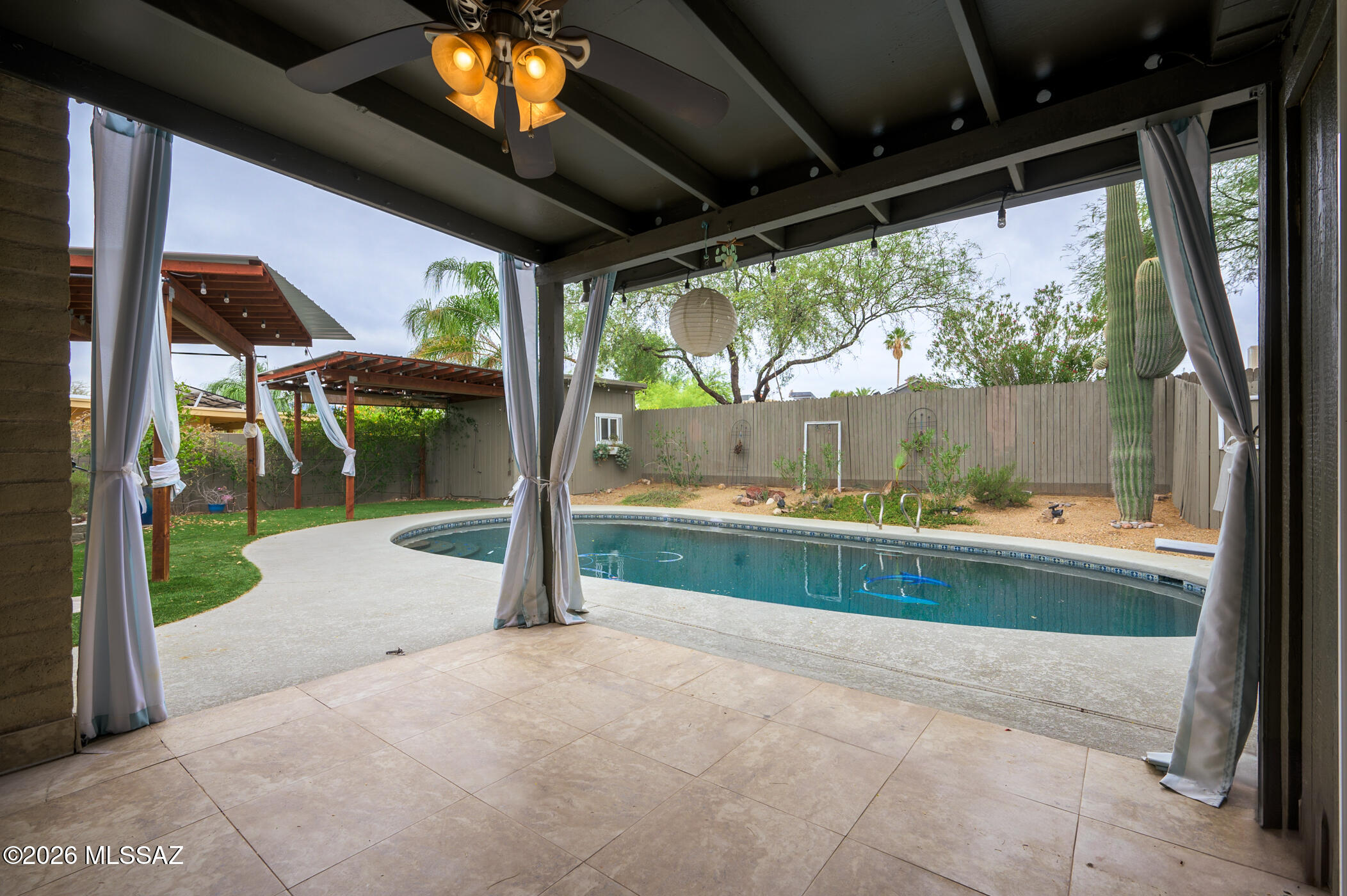 Tucked away in a quiet East Tucson neighborhood with no through traffic, this classic Tucson ranch offers Catalina Mountain views and a backyard designed for enjoying Arizona living. The resort-style outdoor space features a large Pebble Tec pool, multiple cabana areas for relaxing and entertaining, artificial turf, lush Sonoran Desert landscaping, and a spacious storage shed. Inside, the contemporary kitchen with granite tile countertops opens to the dining area and extended family room addition. The living room features a wood-burning fireplace and built-in entertainment center. Brand-new carpet in the bedrooms, updated bathrooms, and large sliding glass doors create seamless indoor-outdoor living. A truly special home!
