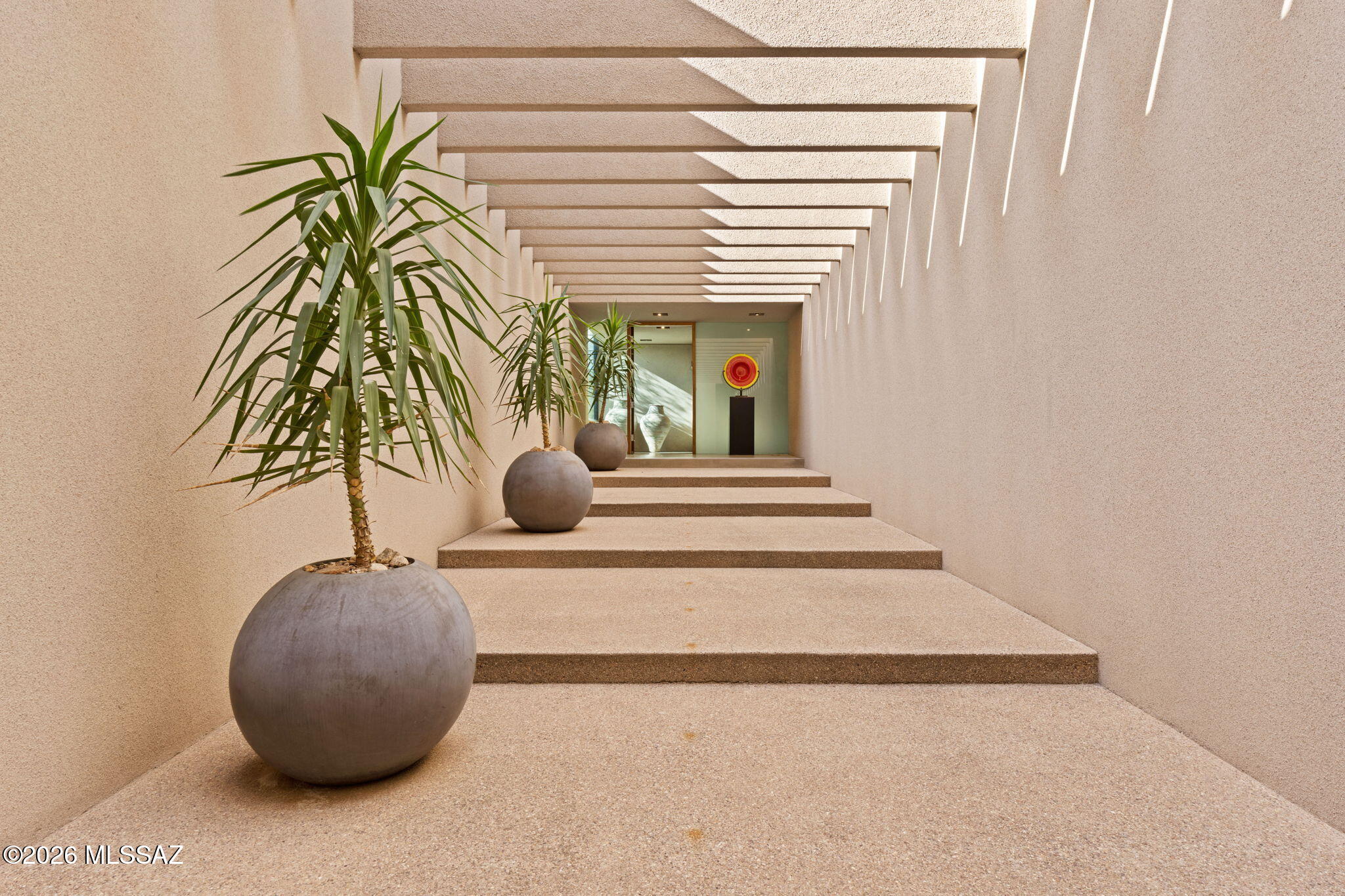 An Architectural Masterpiece by Rick Joy; 
Quite simply one of the finest examples of modern architecture anywhere in the Southwest, this
dramatic Pima Canyon residence designed by internationally acclaimed architect, Rick Joy, is as
much a work of art as it is a home. Privately situated on 1.12 acres within the prestigious guard-
gated enclave of Pima Canyon Estates, this extraordinary property represents a remarkable
convergence of architectural brilliance, understated sophistication, and the breathtaking natural
beauty of the Sonoran Desert. Renowned for his extraordinary ability to create architecture that
seems to rise naturally from the landscape, Joy designed this residence with an artist's eye and a
remarkable understanding of the desert in which it sits. Bold geometric forms, dramatic walls of floor-to-ceiling glass, beautifully executed natural materials, and an ever-changing interplay of light and shadow create an experience that is both visually striking and surprisingly intimate. The magnificent Catalina Mountains provide a spectacular backdrop, with unobstructed views up the Canyon that become an integral part of the architecture itself. Remarkably true to its original design, the residence has been meticulously well maintained by its current stewards and still retains the purity and integrity of Joy's architectural vision. Beautifully milled walnut cabinetry, distinctive Ameristone walls, sophisticated finishes, and thoughtfully proportioned living spaces reflect a level of sophistication and attention to detail rarely encountered today. Nothing feels excessive or unnecessary. Instead, every element has a purpose, creating an atmosphere of quiet confidence and timeless design.
The thoughtfully conceived floor plan includes a privately situated primary suite at the north end of the residence, with a beautifully designed spa-like bath featuring a dramatic glass-enclosed shower illuminated by natural light from above. The kitchen, with its custom walnut cabinetry and generous linear counter space, features Wolf, Viking &; Sub Zero appliances and flows seamlessly into the main living areas and an outdoor grilling station. Additional rooms include a private home office with custom walnut cabinetry that can also serve as an en-suite bedroom, a media room with a walnut TV surround and built-in speakers along with a gas fireplace, and a versatile studio ideal for yoga, art or home exercise which opens through expansive sliding glass doors to a gated courtyard. A separate guest suite with its own private exterior entrance enjoys the same level of finishes and breathtaking Catalina Mountain views offering exceptional privacy  for ones guest. 
Once you step outdoors, the architectural beauty continues with thoughtfully designed courtyards, natural desert landscaping, and a beautifully positioned heated lap pool reflecting the mountains towering above and the expansive desert sky. Above it all, a spectacular rooftop terrace offers panoramic mountain vistas, dramatic sunsets, and the twinkling city lights below- a very rare find in Pima Canyon! An oversized three-car garage and a substantial solar energy system further complement the home.

In a world where so many homes are designed to follow the latest trends, this one was designed to transcend them. More than two decades after its completion, Joy's original vision remains remarkably compelling, a testament to the enduring beauty of truly exceptional architecture. For the discerning buyer who understands that true luxury is not measured by excess, but by exceptional design, this is a rare opportunity to acquire an authentic and significant architectural work by one of the Southwest's most celebrated architects. A truly extraordinary offering in one of Tucson's most coveted communities.