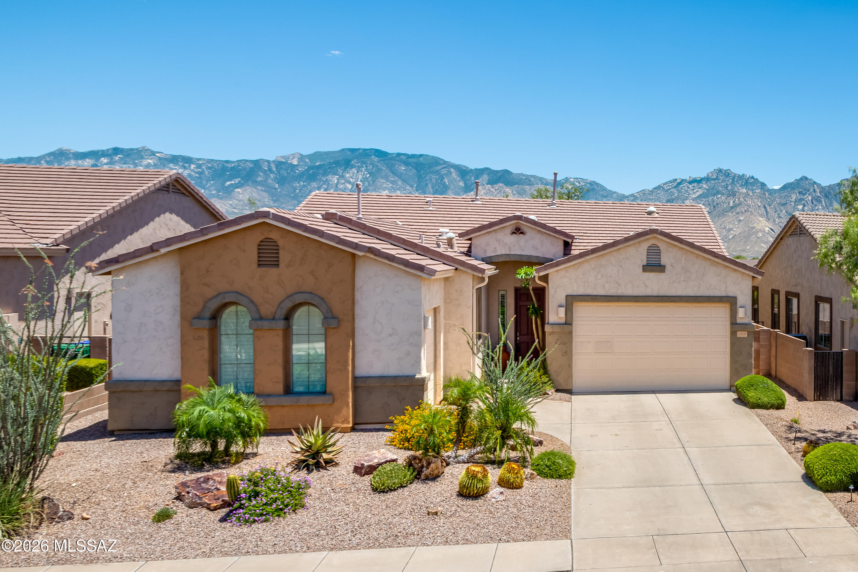 Beautifully positioned on a premium lot overlooking the Vistoso Preserve, this spacious 2,475sf 4BR/2BA home offers panoramic, unobstructed Catalina Mountain views in sought-after Rancho Vistoso. Designed for comfortable desert living and effortless entertaining, the open floor plan features diagonal-set tile flooring, plantation shutters, custom Roman-style soft-fold accordion blinds, custom paint, art niches, and expansive living spaces filled with natural light. The chef's kitchen showcases rich 42'' cherry cabinetry with pull-outs, granite countertops, breakfast bar, pantry with custom shelving, Whirlpool stainless steel appliances, GE gas range with warming oven, built-in microwave, instant hot water, and center island. The spacious great room flows seamlessly to the backyard oasis featuring a covered flagstone patio, built-in BBQ grill, wrought iron view fencing, and endless open space and mountain views. The private primary suite offers plush carpeting, a large walk-in closet with custom organizers, dual executive-height vanities, oval soaking tub, and separate walk-in shower. Additional features include zoned HVAC, ceiling fans throughout, upgraded lighting with dimmers, laundry room with sink and cabinetry, water softener, reverse osmosis system, security pre-wire, and a 3-car garage with epoxy floors, custom shelving, and service door. Furnishings available with separate bill of sale. Ideally located near many of Oro Valley's most desirable lifestyle amenities, outdoor recreation areas, golf, shopping, dining, and trail systems. Residents enjoy easy access to both everyday conveniences and the scenic desert lifestyle that makes Rancho Vistoso so popular.