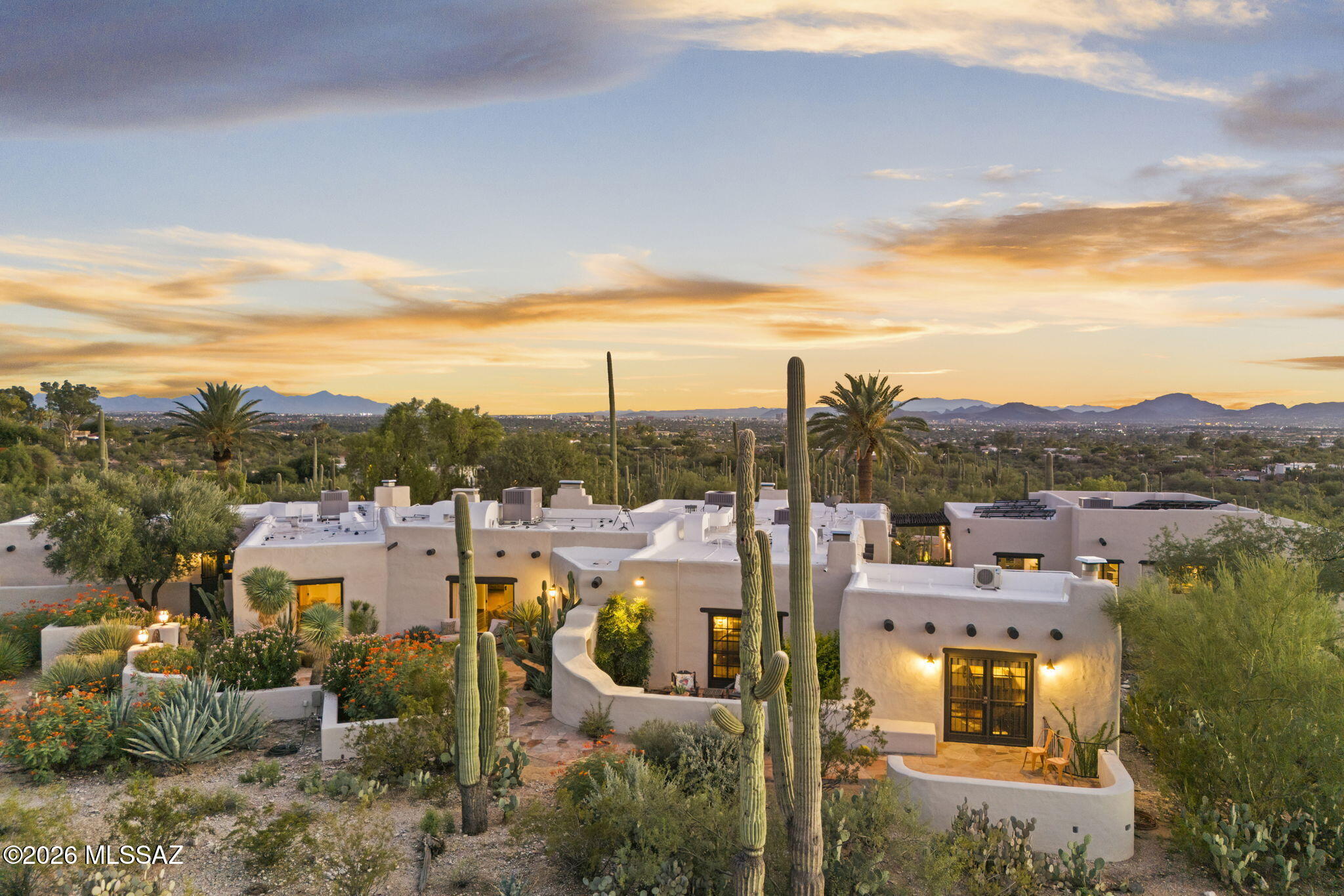 Set at the end of a winding, private gated gravel drive, high on a ridge overlooking the city below with Finger Rock towering above, this magnificent estate occupies one of the Catalina Foothills' finest view lots. From its commanding perch, sweeping vistas stretch across the Tucson Valley toward Baboquivari Peak and, on the clearest days, all the way to Mexico. It is easy to understand why the original owners chose this extraordinary home site nearly a century ago.
Encompassing more than eight acres atop a saguaro-studded hilltop, the estate lies within the magical and coveted ''Old Foothills,'' where money whispers and life seems to move at a slower, more gracious pace. At its heart is an extraordinary 1936 residence designed by renowned Swiss-born architect Josias Joesler, whose work helped define the architectural identity of the Catalina Foothills. The property represents a remarkable convergence of architectural provenance, timeless beauty, understated charm and an increasingly irreplaceable sense of place--a combination unlikely to ever be duplicated.
Guided by an artist's eye and an uncompromising approach to quality, the current stewards have meticulously maintained and thoughtfully updated the estate to a standard rarely encountered in Tucson, particularly in a residence of this vintage. Yet what makes the restoration so successful is not simply what has been added, but what has deliberately been left alone.
The experience begins before reaching the front door. As the drive winds upward through the native desert, the city gradually falls away and the property reveals itself.  Custom antique iron gates announce your arrival and immediately establish the tone.  There is an unmistakable sense of having been transported to another time--a bygone era of gracious desert living that feels increasingly difficult to find, and perhaps impossible to recreate. 
The estate is comprised of a four-bedroom, four-bath main residence together with an attached one-bedroom, one-bath casita offering its own private entrance. A separate two-bedroom, two-bath guest house overlooks the newly completed pool and olive grove, creating a private setting that rivals many of Tucson's finest resorts. Throughout the property, virtually all of the heavy lifting has been completed, including the roof, water lines, septic system, electrical, landscaping, kitchen, interior and exterior paint, lighting and numerous other improvements. Each was undertaken with an uncompromising attention to detail while respecting the character, craftsmanship and architectural vocabulary that define Joesler's most enduring work.  
Original steel casement windows, period door hardware, colored concrete floors, exposed beamed ceilings and hand-carved doors have been carefully preserved. They are complemented by sophisticated modern improvements, including a beautifully appointed new gourmet kitchen with soapstone countertops and top-of-the-line stainless-steel appliances, a basement wine cellar, state-of-the-art security and an entirely new lighting system throughout. The result is a residence that remains remarkably authentic to its history while functioning beautifully for modern-day living. Beyond the architecture lies what may ultimately be the estate's greatest luxury- Land. Approximately eight acres in the very heart of the Catalina Foothills surround the residence, creating a degree of privacy, space and separation that has become increasingly rare. Mature native desert vegetation and towering saguaros frame the property, while the elevated setting provides extraordinary views in nearly every direction. The result feels remarkably removed from the city, yet the estate remains in the heart of the Foothills, with dining, shopping, resorts, clubs and everyday conveniences only minutes away.  For the buyer seeking an even more significant legacy holding, an adjacent parcel of approximately 2.5 acres may also be available, creating the possibility of assembling more than ten contiguous acres in the Old Foothills. In one of Tucson's most established and coveted residential enclaves, an intact holding of this scale has become virtually unheard of. 
Natural wash access and an existing barn--now converted into a workshop and garage for the family "work horse"--also provide intriguing possibilities for the equestrian buyer. The acreage offers equally compelling opportunities for a private family compound, additional guest residences, gardens and recreational amenities, or simply preserving the extraordinary open desert that gives the estate its unmistakable character. More than a residence, this is a rare piece of Tucson's architectural and cultural history: an exceptional Joesler surrounded by the kind of acreage, privacy and untouched Sonoran Desert that recalls the Catalina Foothills as they once were. For the discerning buyer seeking significant architecture, history, privacy, extraordinary views and irreplaceable land, opportunities of this caliber are seldom available--and increasingly impossible to recreate.