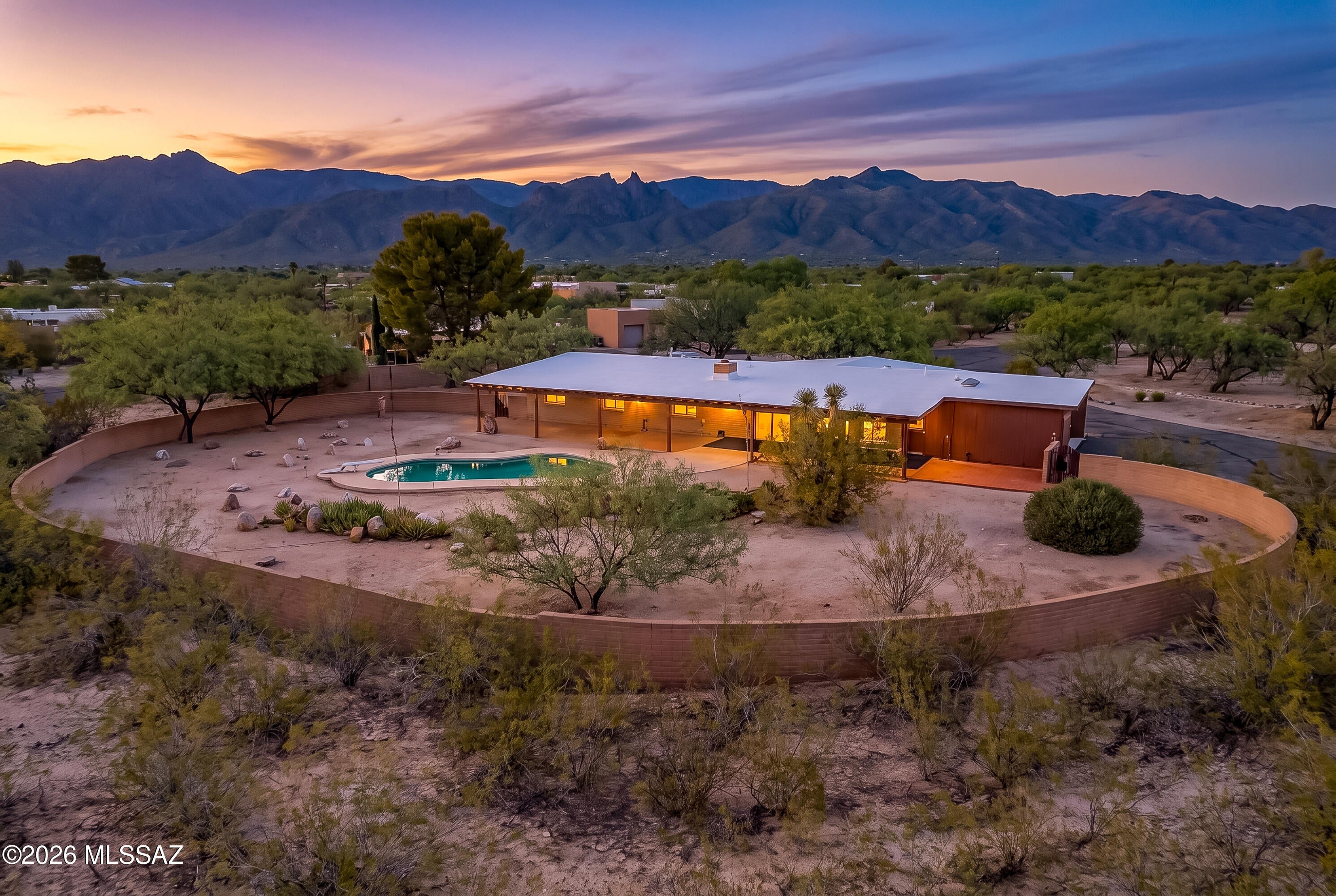 This quality built east side home has been in the care of one family since it was constructed in 1973. With a slump block exterior, spacious floor plan, and numerous updates, this residence is a wonderful opportunity on an expansive acre lot with beautiful mountain views and endless potential! This 4-bedroom, 2.5-bath home offers a flexible layout with two separate living areas and plenty of room to make it your own. Classic features like the masonry fireplace and large windows, and upgraded appliances and bathrooms create pleasant interior spaces and piece of mind. The extraordinary backyard is a standout feature, complete with a pool and an abundance of covered and open spaces for entertaining, outdoor living, gardening, a play area, or creating your own private desert retreat. A carport provides convenient covered parking. While the home is ready for its next owner's personal touches and updates, the generous lot, spacious layout, and beautiful surroundings provide an incredible foundation to create something truly special. This convenient location offers a perfect balance of privacy and proximity to the Tanque Verde Corridor, McDonald Park, and Mount Lemmon.