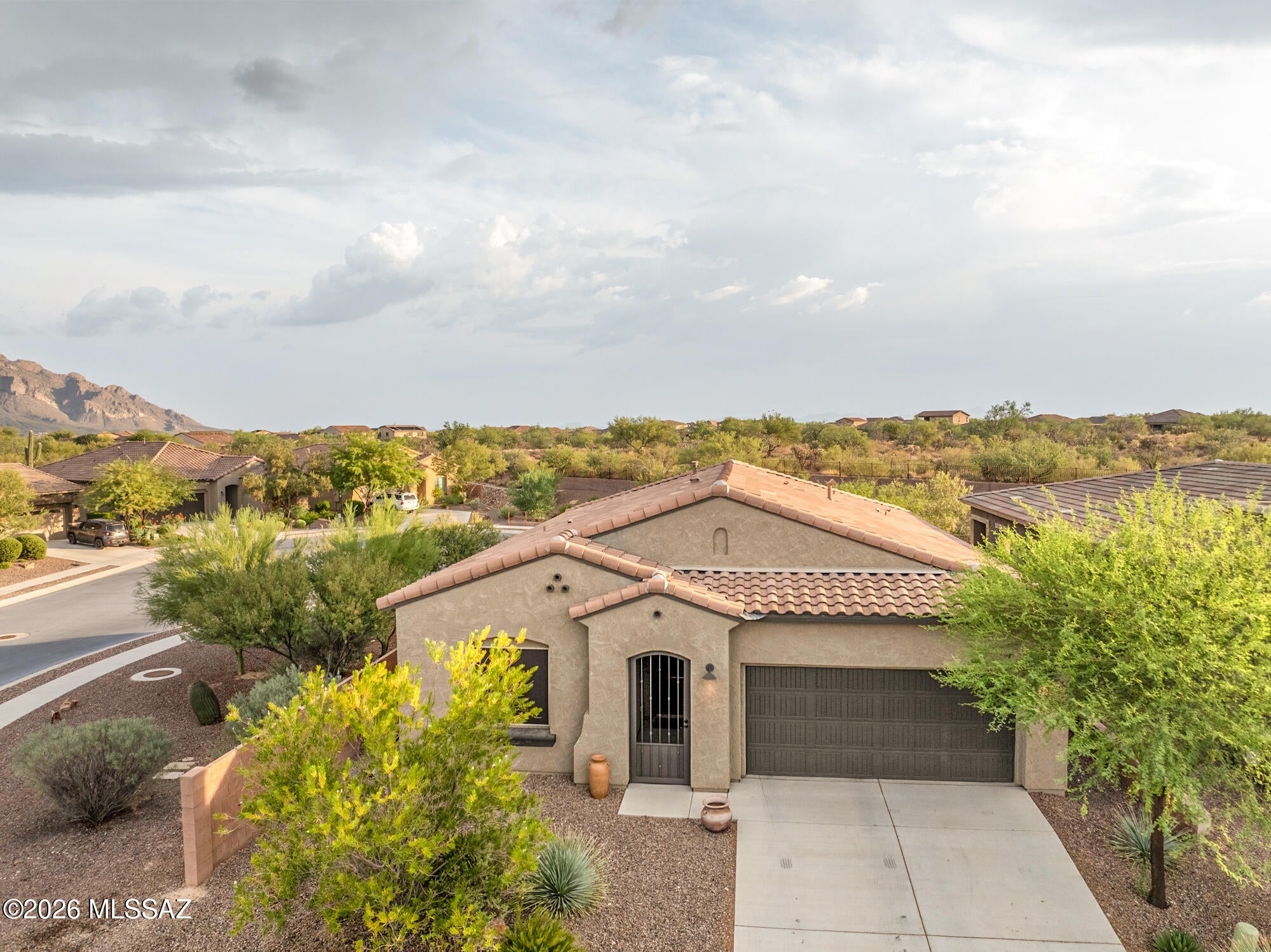 Welcome to this beautifully upgraded home in Viewpointe II community of Oro Valley, where modern finishes, thoughtful improvements, and stunning desert surroundings come together to create a truly move-in-ready retreat. Offering approximately 1,537 square feet with 2 bedrooms, 2 bathrooms, and a versatile den/office, this home has been extensively enhanced with high-quality finishes throughout. The interior showcases gorgeous wood-look porcelain tile flooring imported from Spain and updated lighting, door hardware, and window treatments throughout the home. The completely refreshed kitchen features a professional Wolf range, VentAHood ventilation system, new refrigerator, custom walnut butcher block countertops and shelving, painted cabinetry, and an updated sink and faucet, creating a space that is equally suited for everyday living and entertaining. The primary suite offers a beautifully updated bathroom with painted cabinetry, new countertops, sinks, plumbing fixtures, lighting, backsplash, shower flooring, and toilet. The secondary bathroom has been fully renovated with a new tile shower, vanity, flooring, fixtures, and lighting, providing a fresh, contemporary feel for guests and family alike. Step outside to enjoy Arizona living at its best. The screened-in patio creates a comfortable outdoor living space, while exterior solar screens enhance energy efficiency. The backyard has been thoughtfully landscaped with a new irrigation system, citrus trees, raised garden planters, shrubs, and paver hardscaping. Additional upgrades include a custom iron entry gate, epoxy-coated garage floor, and a new water heater. Catalina Mountain views and convenient access to Oro Valley's amenities, this meticulously maintained home offers a rare combination of quality, comfort, and style.