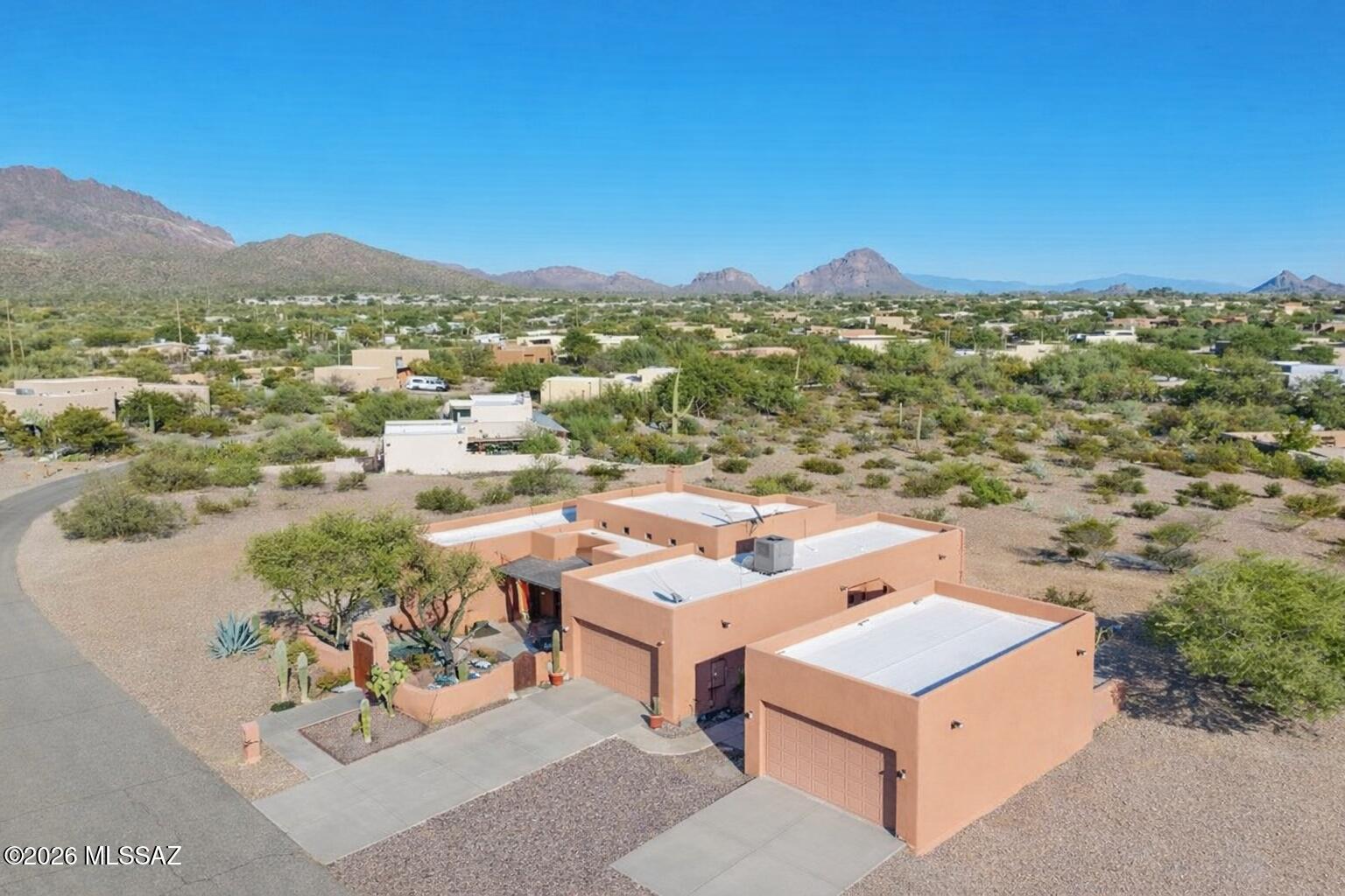 Beyond the winding desert roads of Tucson, where the Sonoran sky stretches wide and the mountains blush at sunset, there waits a beautiful Santa Fe-style sanctuary. Peaceful 0.9-acre homesite, where freedom reigns with NO HOA. Also enjoy a newly installed HVAC system and Newly Coated Roof.

Inside, soft desert light spills across warm finishes, ceramic tile throughout (No Carpet) guiding you toward the heart of the home -- an inviting living space centered around a classic indoor beehive fireplace, where evenings feel softer and conversations linger longer. The kitchen is a gathering place by design spacious, welcoming, and filled with abundant light oak cabinetry and a generous breakfast bar, ready for morning coffee, shared meals, and the simple joys of everyday life.

With three spacious bedrooms, two baths, a dedicated office, and an additional flex room, this home offers space for both quiet moments and inspired living. The primary suite is a retreat of its own, featuring a beautifully tiled walk-in shower and the peaceful comfort of a space designed for rest and renewal.

An east-facing backyard keeps the afternoons cool and shaded, creating the perfect setting for long summer days. An extended covered patio overlooks your private oasis a sparkling pool and spa surrounded by resort-style landscaping. As twilight settles in, the outdoor beehive fireplace glows softly, turning ordinary evenings into something unforgettable.

For collectors, creators, and car enthusiasts, the property offers exceptional flexibility a 2-car garage plus a separate 2-car garage/workshop, with room for up to six vehicles depending on size.