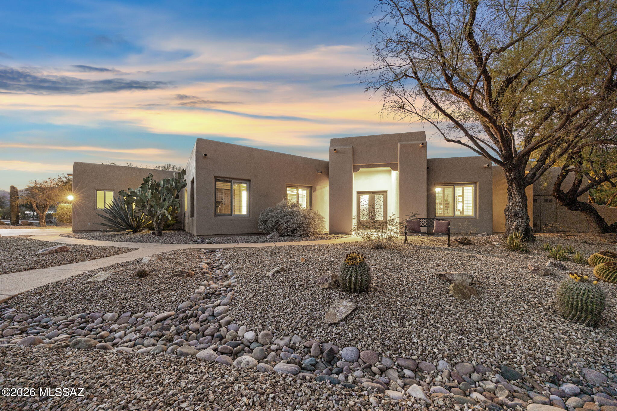 Extraordinary Sabino Springs Estate on Rare Double Lot.  Situated on two premium view lots within the prestigious guard-gated golf community of Arizona National Golf Club, this extensively remodeled estate offers an exceptional combination of luxury, privacy, versatility, and breathtaking scenery. Encompassing nearly one acre with no neighbors on three sides, the property features a 2,936 sq ft, 4 bedroom main house with 3 car garage, a 744-square-foot detached guest house, and a massive climate-controlled garage complex with activity room/guest room with bath and 8 garage spaces, for a total of 11 garage spaces on the property.  The single-level main home showcases elegant travertine flooring, soaring 12-foot ceilings, custom alder doors, plantation shutters, and spectacular Catalina Mountain views. The gourmet kitchen features custom white cabinetry, illuminated glass-front display cabinets, a large center island with breakfast bar, and a separate breakfast nook. The family room is anchored by a striking stone gas fireplace with a custom carved wood mantel, while the primary suite offers dual walk-in closets and a private retreat atmosphere.  Ideal for multigenerational living, extended guests, the detached guest house includes two bedrooms, a full bath, a flex room with kitchenette and sitting area, a private patio, and its own security system.  Car enthusiasts, collectors, hobbyists, and entrepreneurs will appreciate the impressive detached garage and studio complex, offering over 2,300 square feet of climate-controlled space, room for up to eight vehicles, a private bath, studio area, and flexible-use space for fitness, sports training, workshops, hobbies, or additional storage.  Outdoor living is equally impressive, featuring mature desert landscaping with towering saguaros and mesquite trees, decorative rock walls, large petrified wood specimens, a backyard basketball court, jacuzzi hot tub, outdoor fireplace, custom privacy screens, and a rooftop observation deck accessed by a spiral staircase with panoramic 360-degree views of the Catalina Mountains, golf course, and city lights.Residents enjoy 24-hour guarded entry, access to community amenities including a pool, spa, fitness center, golf privileges, dining discounts, and direct access to nearby Catalina Mountain hiking trails. Recent updates include exterior paint in 2024, newer HVAC systems for both residences, newer water heater, and epoxy-coated garages, patios, and driveway.  A truly unique Arizona estate offering luxury living, exceptional flexibility, and unmatched mountain and golf course views.