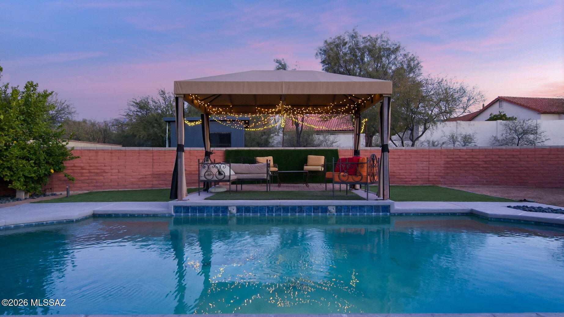 Nestled in the established and highly sought-after Sabino Vista community, this inviting residence beautifully blends character, flexibility, and true Tucson outdoor living. Set on a generous .37-acre lot, the property offers an exceptional sense of space and privacy. A spacious courtyard entry, thoughtfully designed as an ''outdoor living room'' and dining area with pavers, sets the tone for relaxed desert living and unforgettable gatherings beneath the Arizona sky. Inside, a welcoming foyer and rich hardwood flooring, create warmth and continuity throughout the main living areas. Designed with versatility in mind, the ideal split-bedroom floor plan features an expansive private wing perfect for multigenerational living or extended guests, complete with its own bedroom, bathroom, spacious living room, full kitchen, and pantry offering independence without sacrificing connection.
At the heart of the home, the well-appointed kitchen with Cherry cabinetry, gorgeous green gemstone-looking granite slab counters and a sink to match, stainless steel appliances, and a breakfast bar that opens seamlessly to the family room, anchored by a cozy fireplace and a picture window that frames the backyard. A private dining area and an additional living room with French doors provide effortless indoor-outdoor flow, inviting natural light, and easy access to the outdoor retreat. The secondary bedrooms are thoughtfully positioned on the opposite wing, providing generous proportions and a natural sense of privacy for everyday living.
Outdoors, the oversized north-facing backyard captures the essence of Tucson's year-round lifestyle. A refreshing, thoughtfully designed pool serves as the sparkling centerpiece of the backyard, beautifully enjoyed from the full-width covered patio or the charming, softly illuminated gazebo. Multiple inviting spaces for outdoor cooking, dining, and relaxed lounging create effortless flow for gatherings of any size, while a discreet wire spanning the pool is ready to transform the space into an open-air theater for impromptu movie nights under the stars. Every detail of this inviting retreat has been curated to inspire memorable entertaining or quiet evenings soaking in Tucson's vibrant sunsets and breathtaking, star-filled skies. With the Catalina Mountains as a backdrop and no power lines in sight, the setting feels both serene and expansive. Ideally located just moments from Sabino Canyon Recreation Area, world-class hiking and biking trails, as well as popular restaurants and convenient shopping, this Sabino Vista residence offers not only a beautiful home.