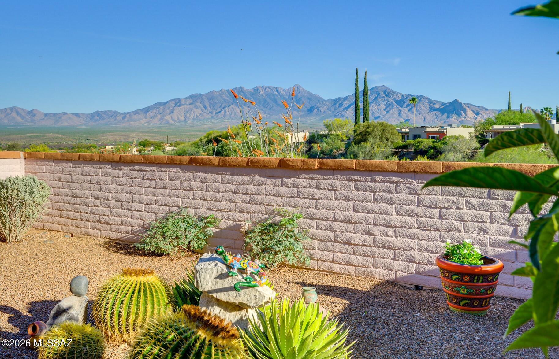 This home is located on a dream lot with stunning views and endless desert vistas stretching across the wide-open range, with the Santa Rita Mountains providing a scenic backdrop. Upon entering the townhome, one is immediately struck by the exquisite Saltillo tile flooring that reflects the distinctive character of the Southwest.  The landscaping efforts are enhanced by the presence of diverse desert vegetation in both the front and rear yards. The kitchen is enhanced by a brilliant skylight that illuminates the stainless steel appliances, while an eat-in nook offers convenience for enjoying lighter meals.  The dining area seamlessly connects to a tranquil living room, which features patio doors that invite the stunning vistas indoors. Just step outside to extend the living space under the extended wood beam and post-covered patio adorned with Spanish Saltillo tile flooring. You will relish the experience of witnessing sunrises, sunsets, and a sky filled with stars every day - this home will warm your heart!