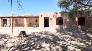 This unique property has distinct Old West Charm! Three houses with rental potential and lots of storage. 2 bedroom 2 bath home (1578 sq. ft.) that's handicap accessible, guest house with 1 bedroom and 1 bath (600 sq. ft.), third home is nicely updated with 1 bedroom and 1 bath (1,000 sq. ft.) with separate laundry room and storage. Spacious wood shop could be great for your hobby area, separate cantina that can be used for office or Air BNB. Homes are on Pomerene water plus private irrigation well, drip system installed for trees and plants at the 1094 property. The entire 5.56 acres are fenced and cross fenced perfect for horses and livestock.
