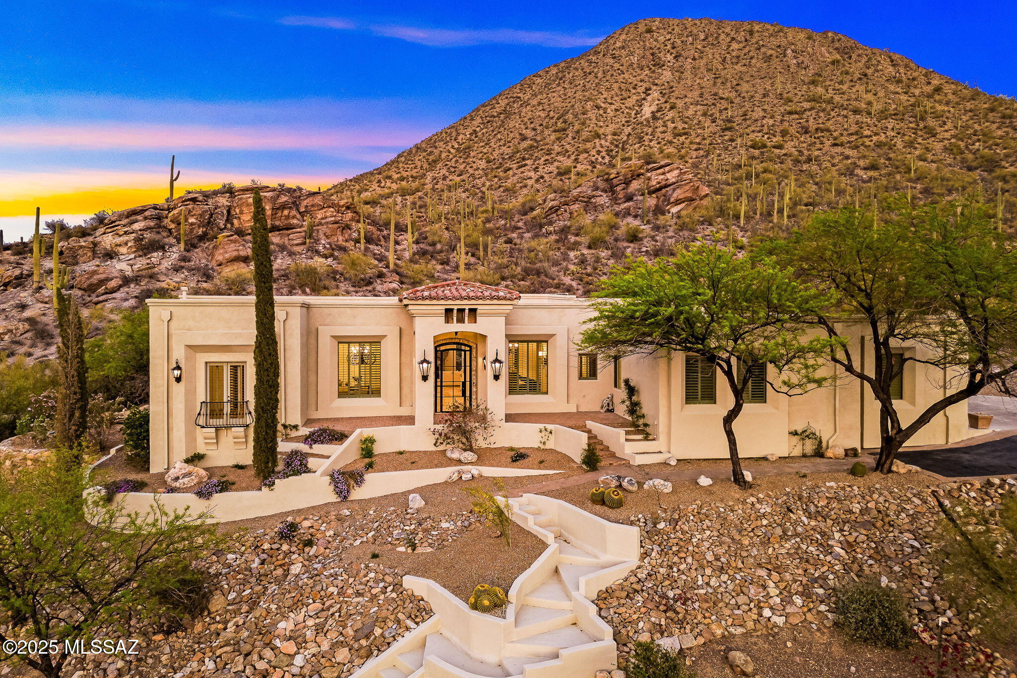 Perched high on a mountain in an exclusive gated community, this exquisite 4,891 sq ft home offers unparalleled views and luxurious desert living at its finest. With 4 spacious bedrooms and 3.5 bathrooms, this residence is a true sanctuary.

Enter through a large custom glass door framed by cantera stone, setting the tone for the elegance that awaits inside. Soaring ceilings and travertine tile throughout create a light, expansive feel, while a neutral color palette provides timeless sophistication.

The massive living room features a stunning cantera stone fireplace, mirrored in the game room with a second matching fireplace—perfect for cozy evenings or entertaining guests. The chef's kitchen is a showstopper with a Viking range, custom hood, and generous prep space. Enjoy versatile living with a formal dining room, cozy sitting area, and spacious game room. Step outside to your own private resort-style oasis featuring a sparkling pool, outdoor fireplace, patio and look-out area to take in the sweeping mountain and city views.

Additional features include a 3-car garage, air-conditioned workshop/hobby room, and exquisite cantera stone details throughout the home's exterior.

A rare opportunity to own a luxurious retreat with exceptional craftsmanship, privacy, and those breathtaking mountain-top views.