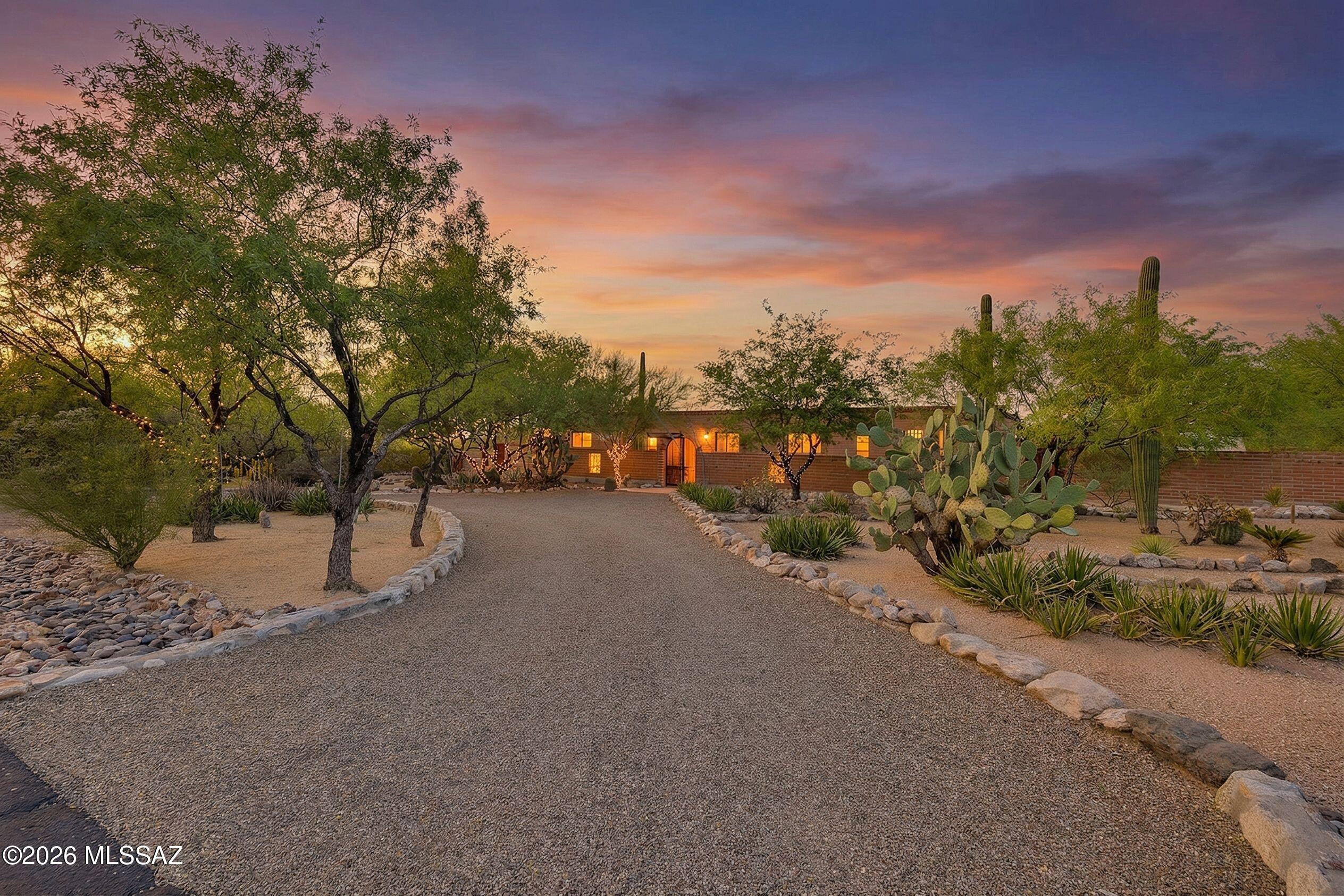 A rare find in Northwest Tucson! This exceptional property has six garage spaces, a dream setup for collectors, hobbyists, or anyone in need of serious storage or additional entertaining space. Situated on nearly an acre, the fully fenced lot offers a true park like setting complete with a large, covered patio, sparkling pool, and stunning mountain views.  This home offers endless extras, multiple storage sheds, a greenhouse, and more...providing incredible versatility for your lifestyle needs. The classic burnt adobe home showcases timeless Southwest craftsmanship and has been meticulously maintained and thoughtfully updated. Inside, you'll find 3 bedrooms and 2 baths, including a spacious primary suite featuring a custom closet and a cozy seating area. The beautifully updated kitchen boasts maple cabinets, granite countertops, and its own fireplace. This one of a kind home blends charm, functionality, and space in a highly desirable location.
