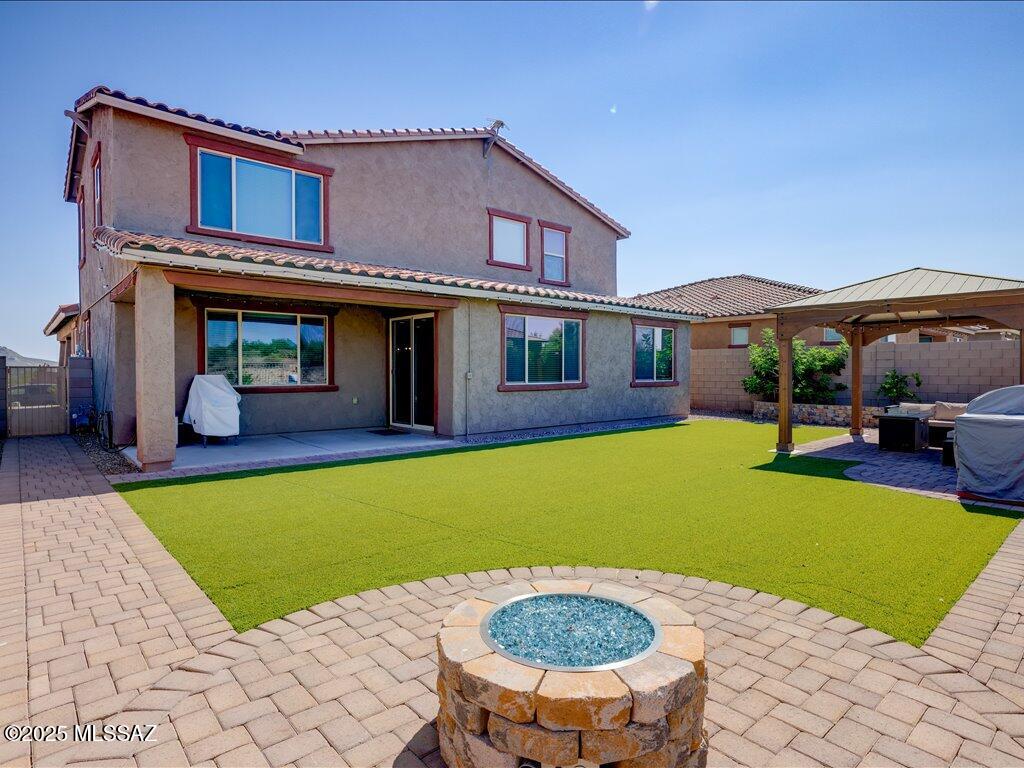 Located in the gated Villages at Silverhawke, this 2022 Meritage home offers modern elegance, energy efficiency, and stunning Catalina Mountain views. The flexible floorplan includes 5 bedrooms, 4 bathrooms, two ensuite bedrooms, a den/flex room, and an upstairs loft—perfect for a variety of living needs. Contemporary finishes elevate every space, while the great room opens to a backyard retreat with a covered patio, gazebo, built-in firepit, and raised garden planters. The owned solar system will be paid off at closing, keeping electric bills under $100/month. Tenant-occupied through August.